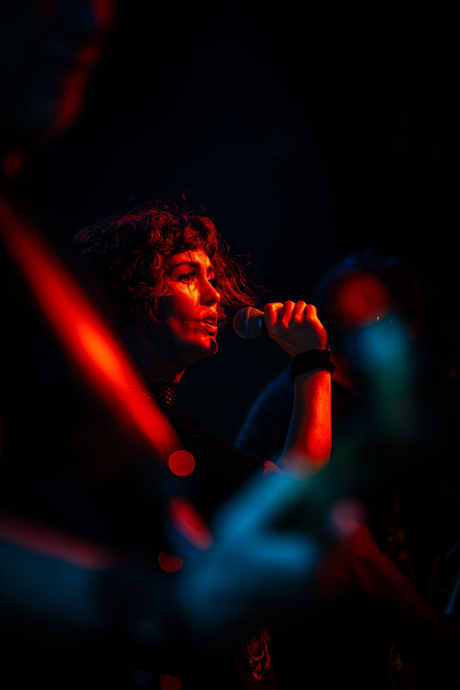 Atmospheric concert photo with red and blue lighting creating a moody ambiance.