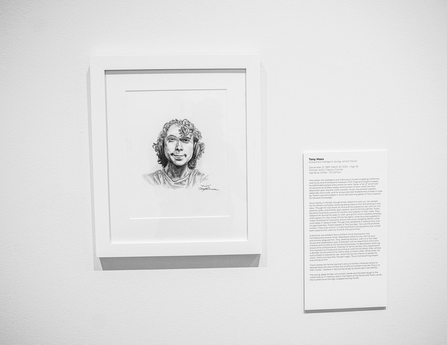 Art gallery wall showing framed sketches with accompanying text descriptions on white background.