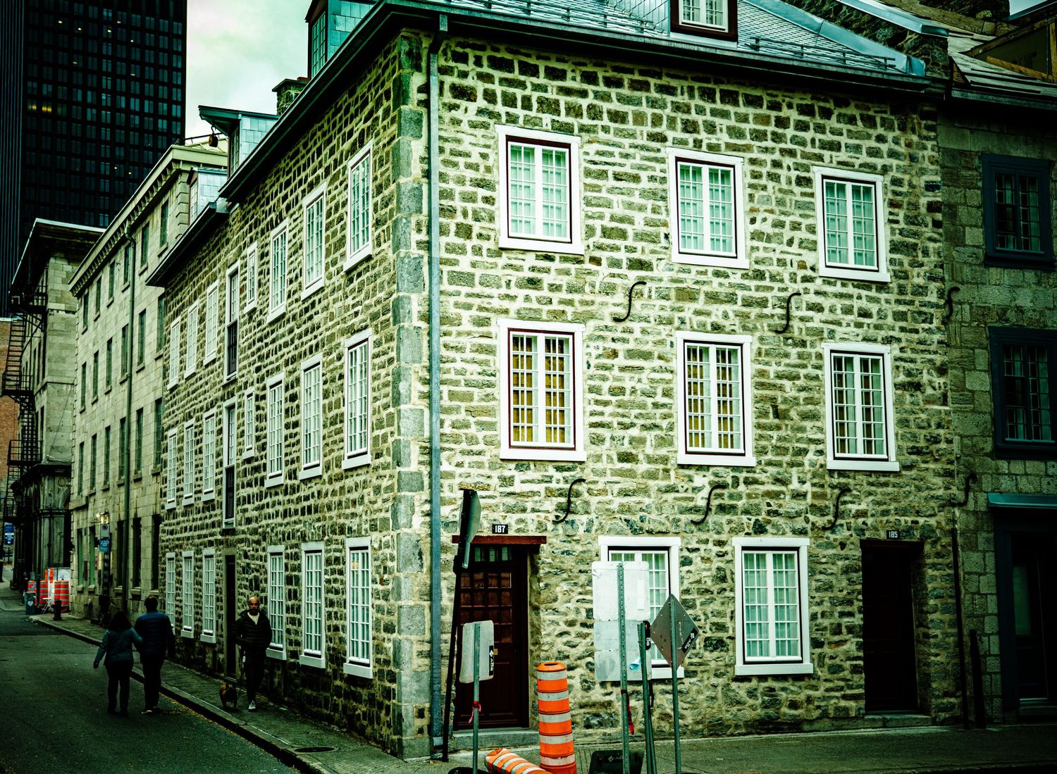 Historic stone buildings line a narrow cobblestone street in Quebec City's old town district.