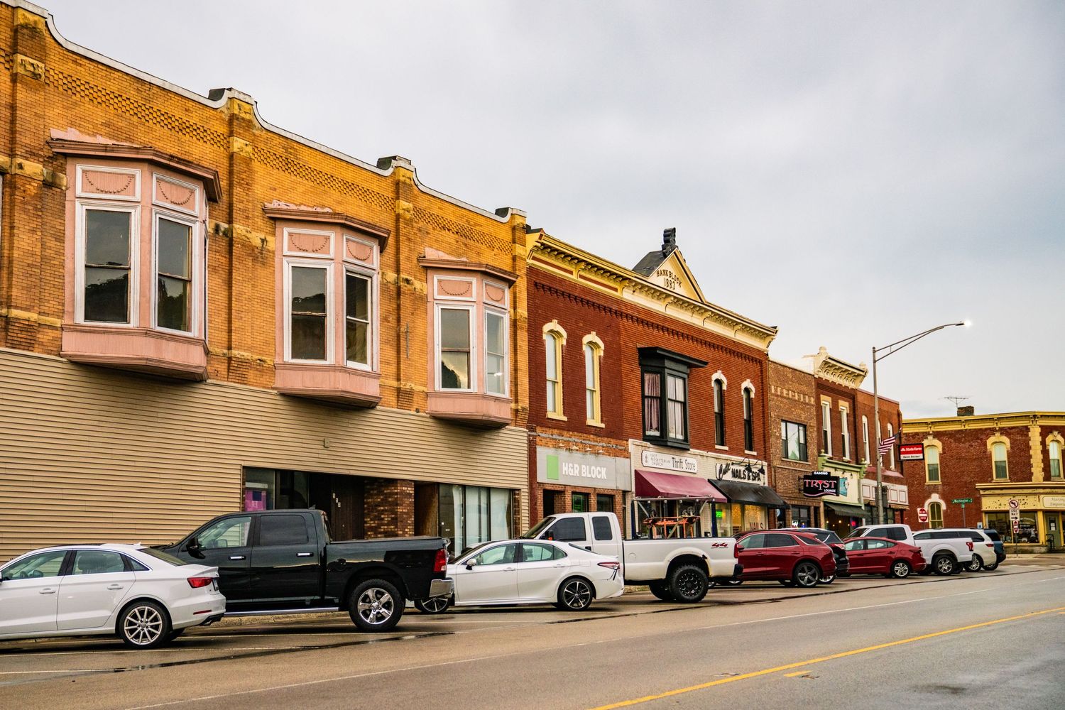 Row of vintage brick commercial buildings along a small town main street.