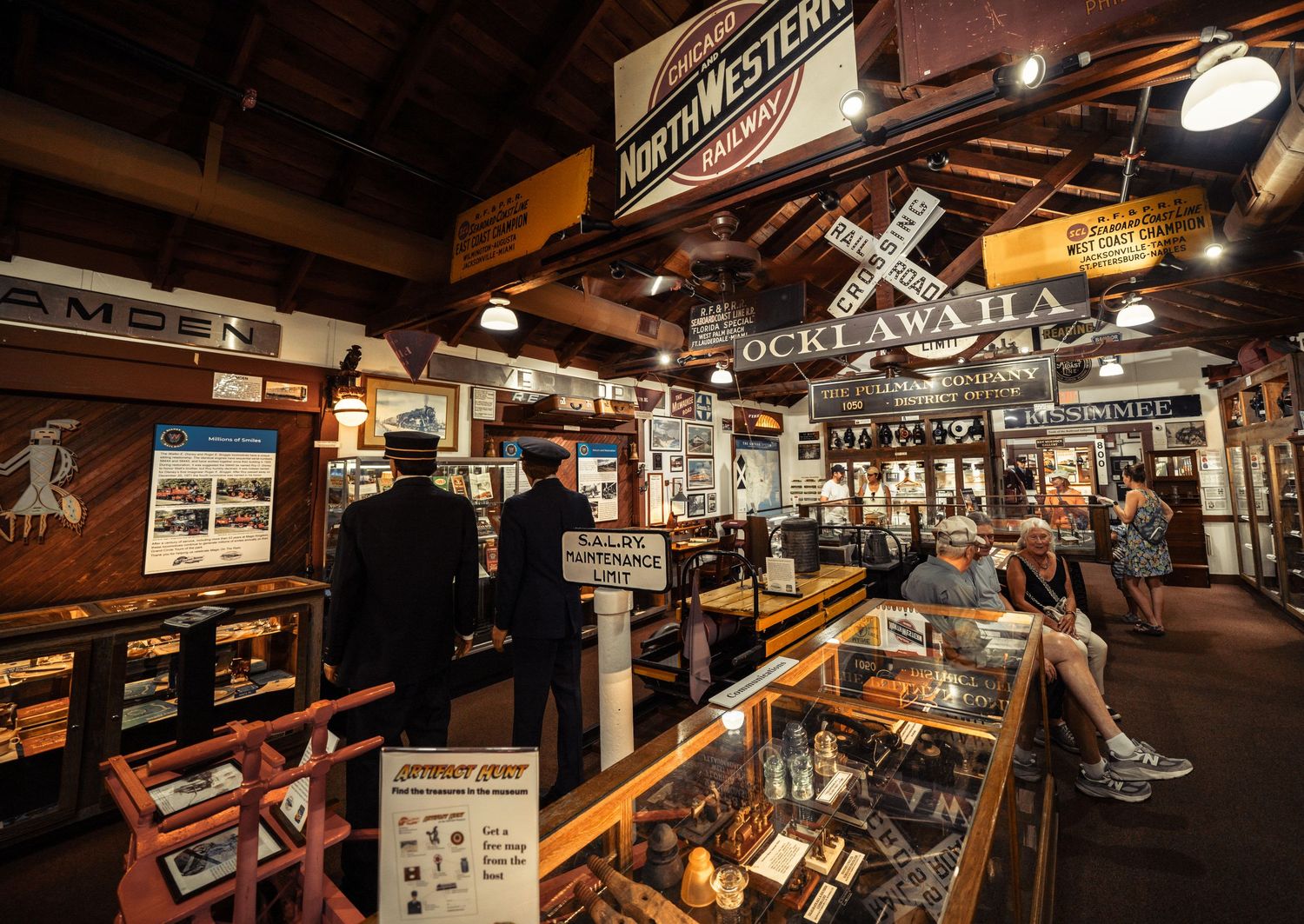 Vintage railroad museum display showcases antique equipment and memorabilia along wooden walls with warm lighting.