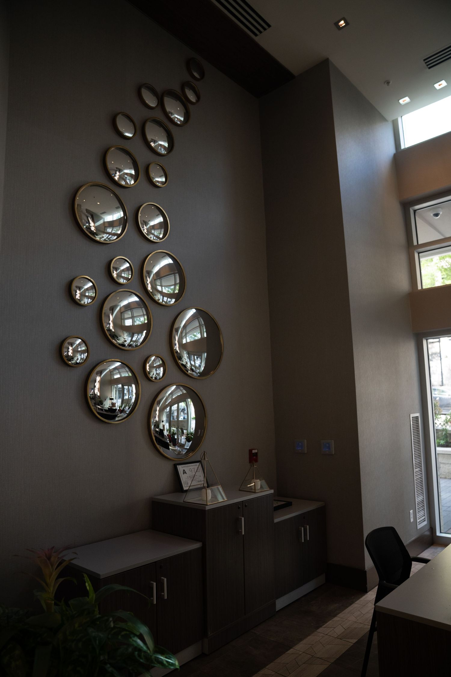 Contemporary wall installation with circular mirror bubbles creating reflective pattern.