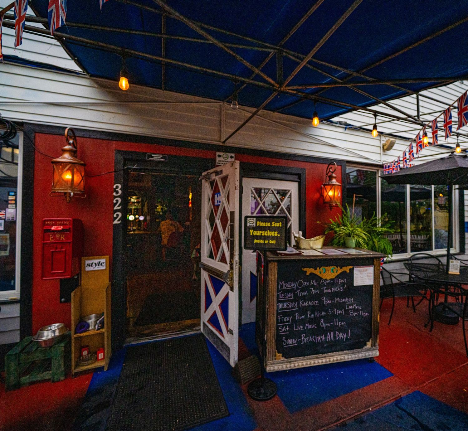 Covered market stalls with blue and white awnings and red walls displaying local goods.