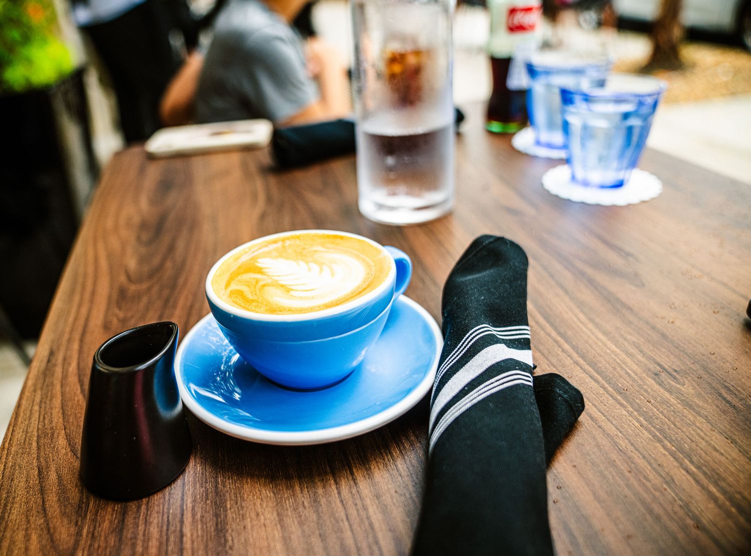 Coffee cups with latte art on wooden table at a cafe setting.