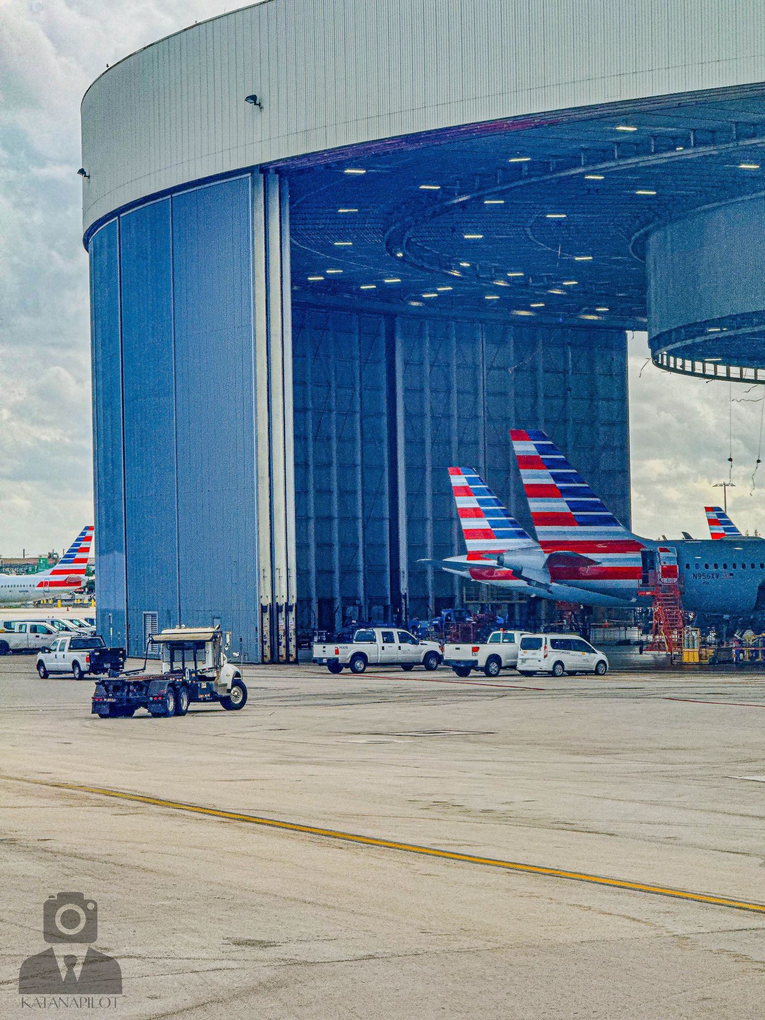 Large American Airlines hangar facility with multiple red and blue aircraft tails visible.