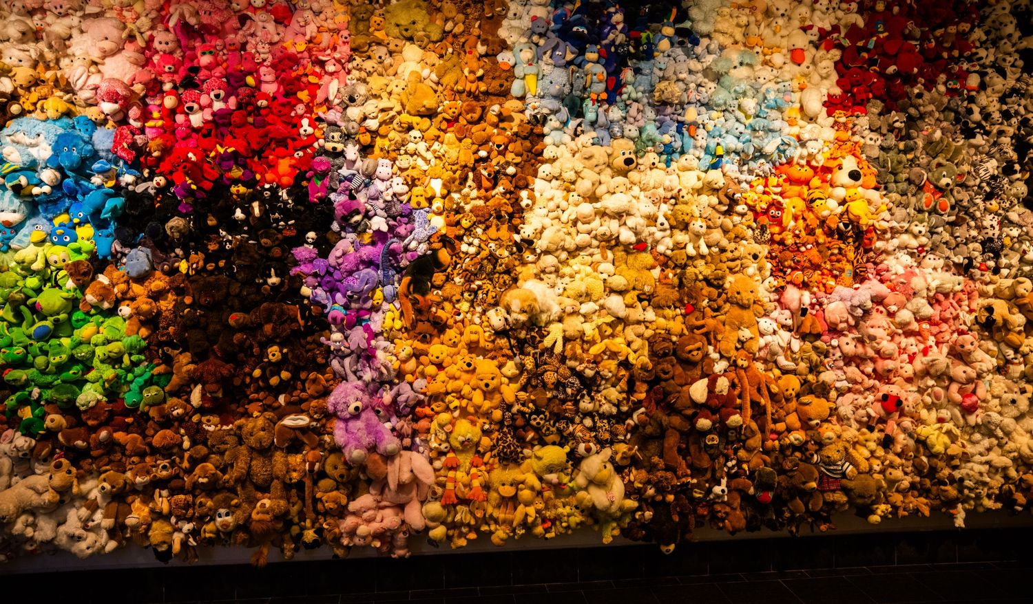 Vibrant autumn leaves create a colorful mosaic pattern against a dark background in dramatic lighting.