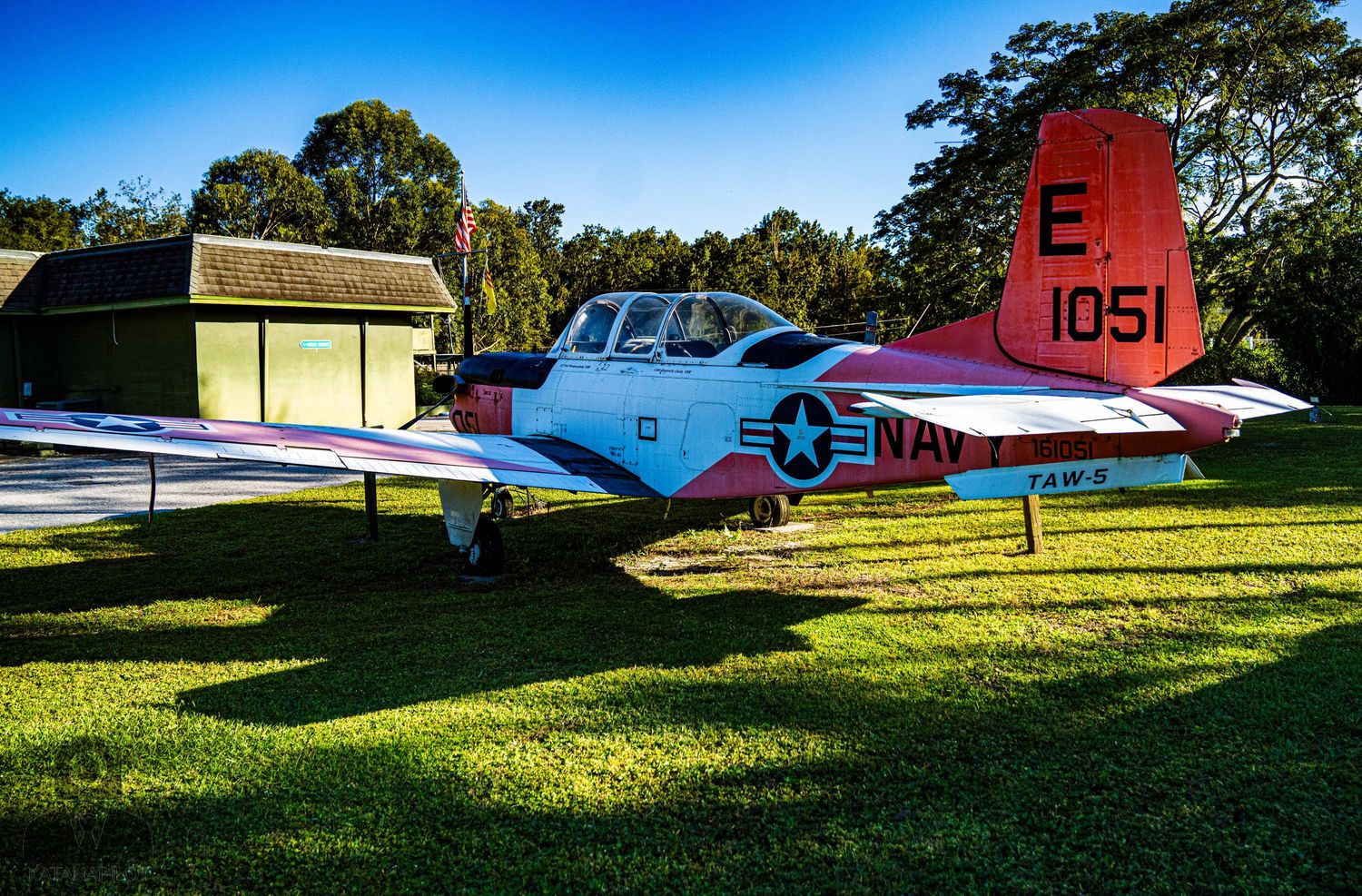 Military aircraft on display at an outdoor museum with green grass and blue sky in the background.