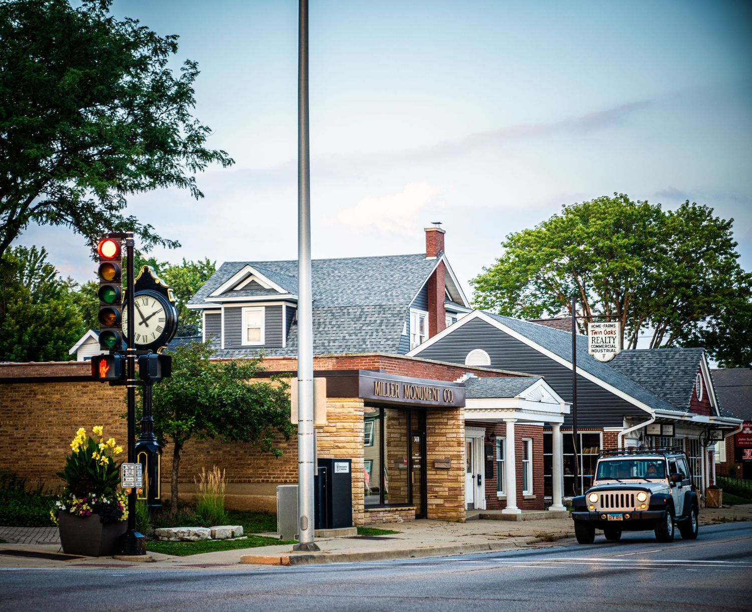 Classic small-town main street corner with colonial architecture and decorative lamp post.
