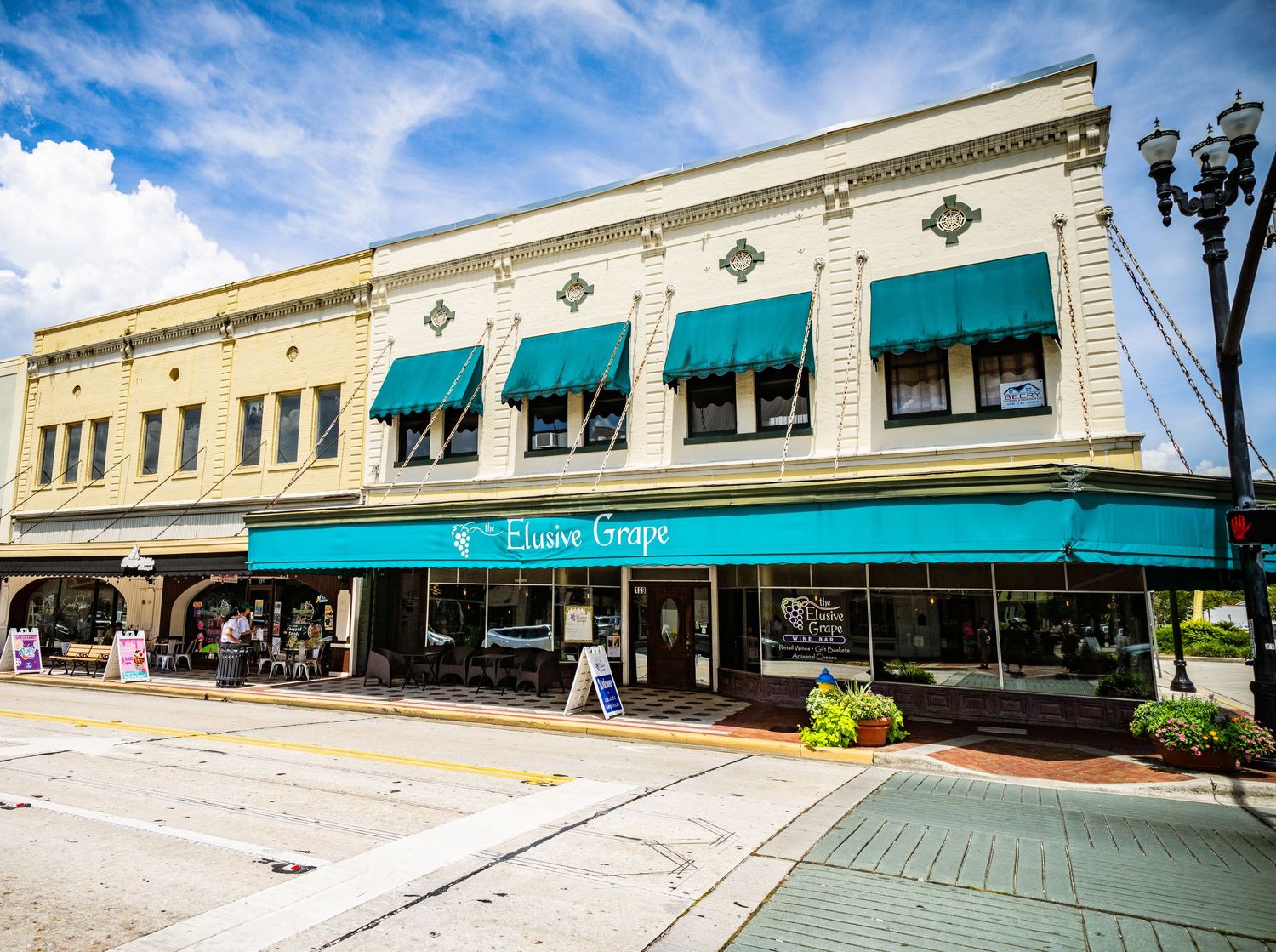 Large historic commercial building with green awnings and decorative architectural details.