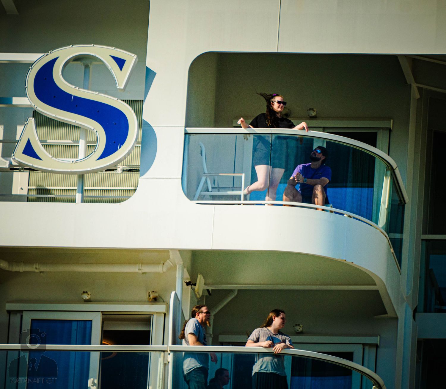Cruise ship balconies with a large blue 'S' logo visible on the exterior of the vessel.