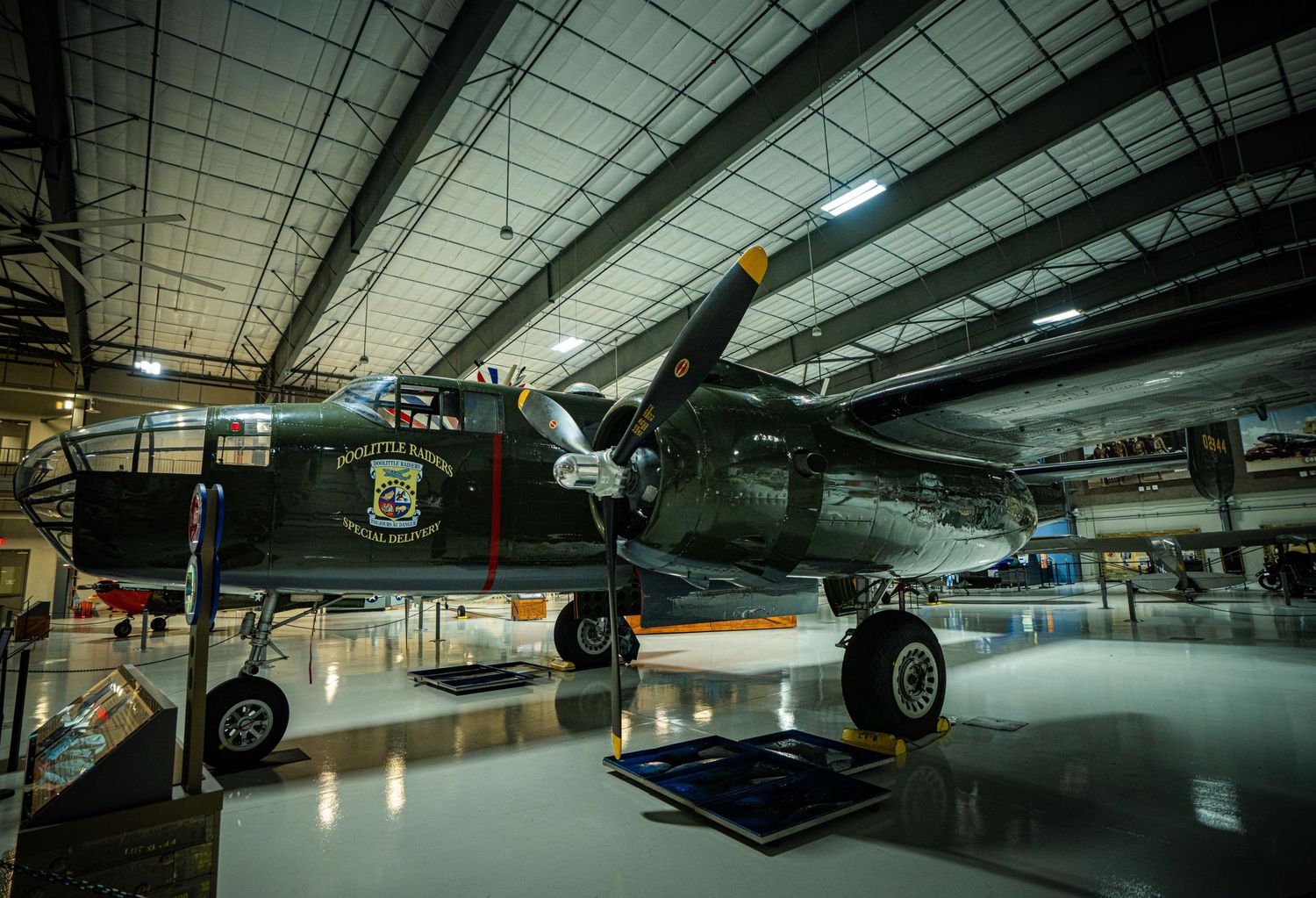 Vintage WWII twin-engine bomber aircraft on display inside a spacious aviation museum hangar.