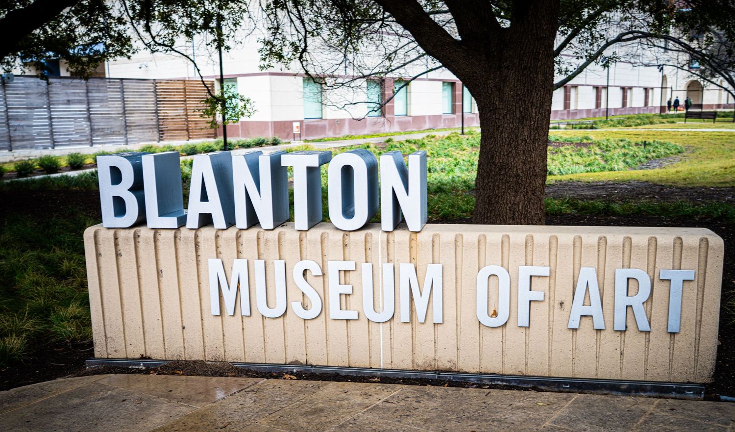 White lettering spelling out Blanton Museum of Art against a concrete barrier wall.