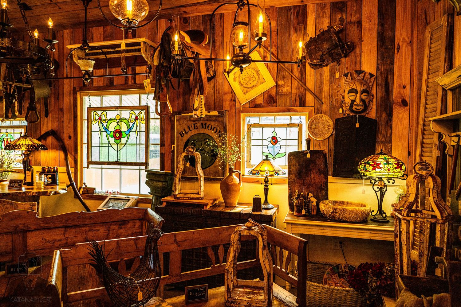 Atmospheric vintage shop interior with stained glass windows and antique lamps casting golden light.