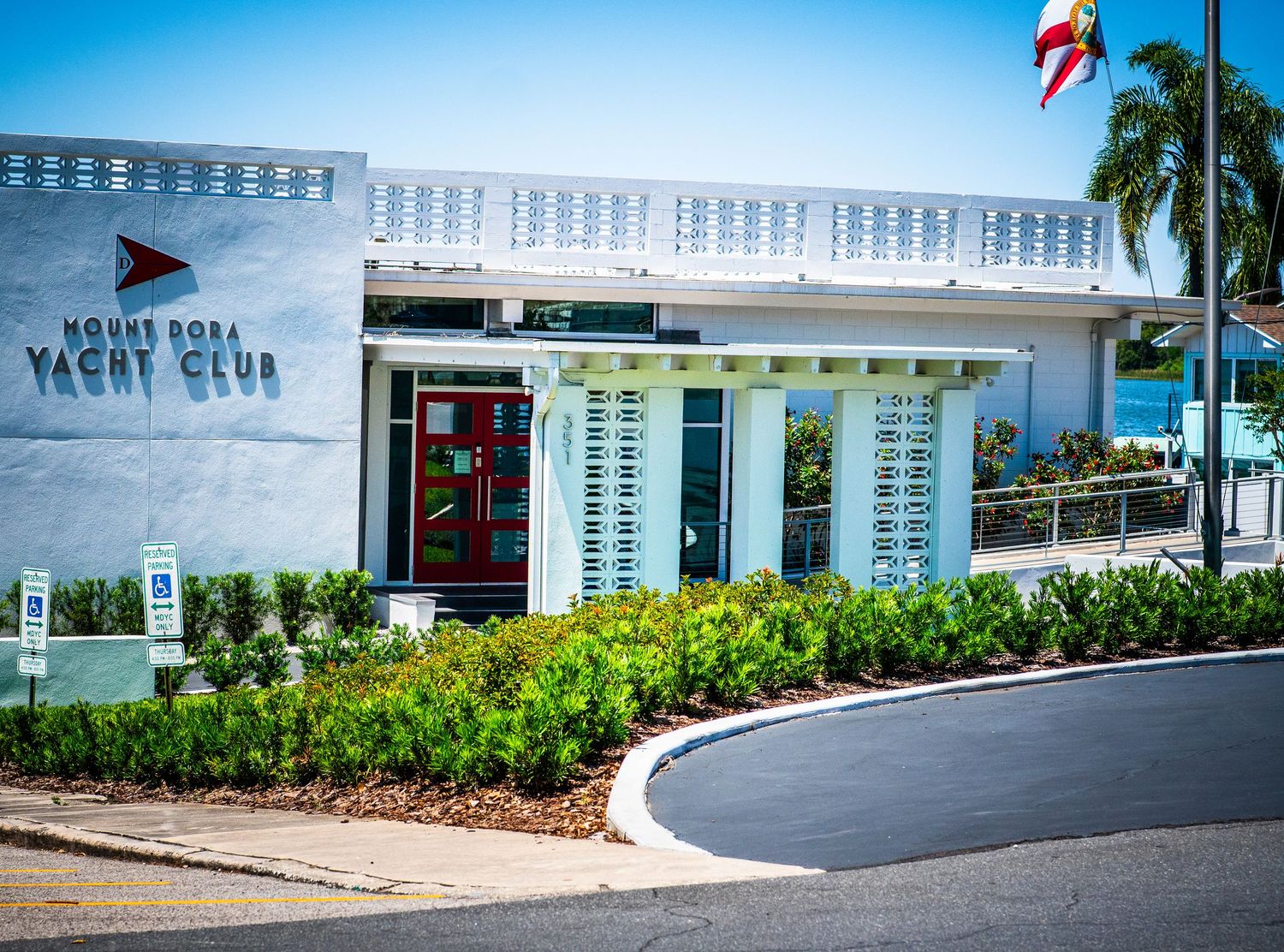Mount Dora Yacht Club entrance with manicured hedges and curved driveway.