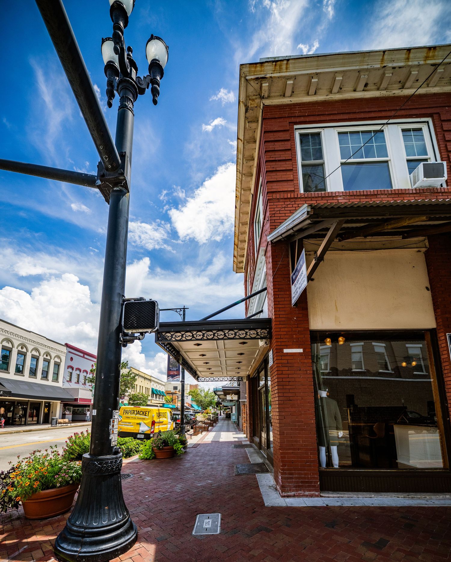 Low-angle view of brick buildings and covered walkways against blue sky.