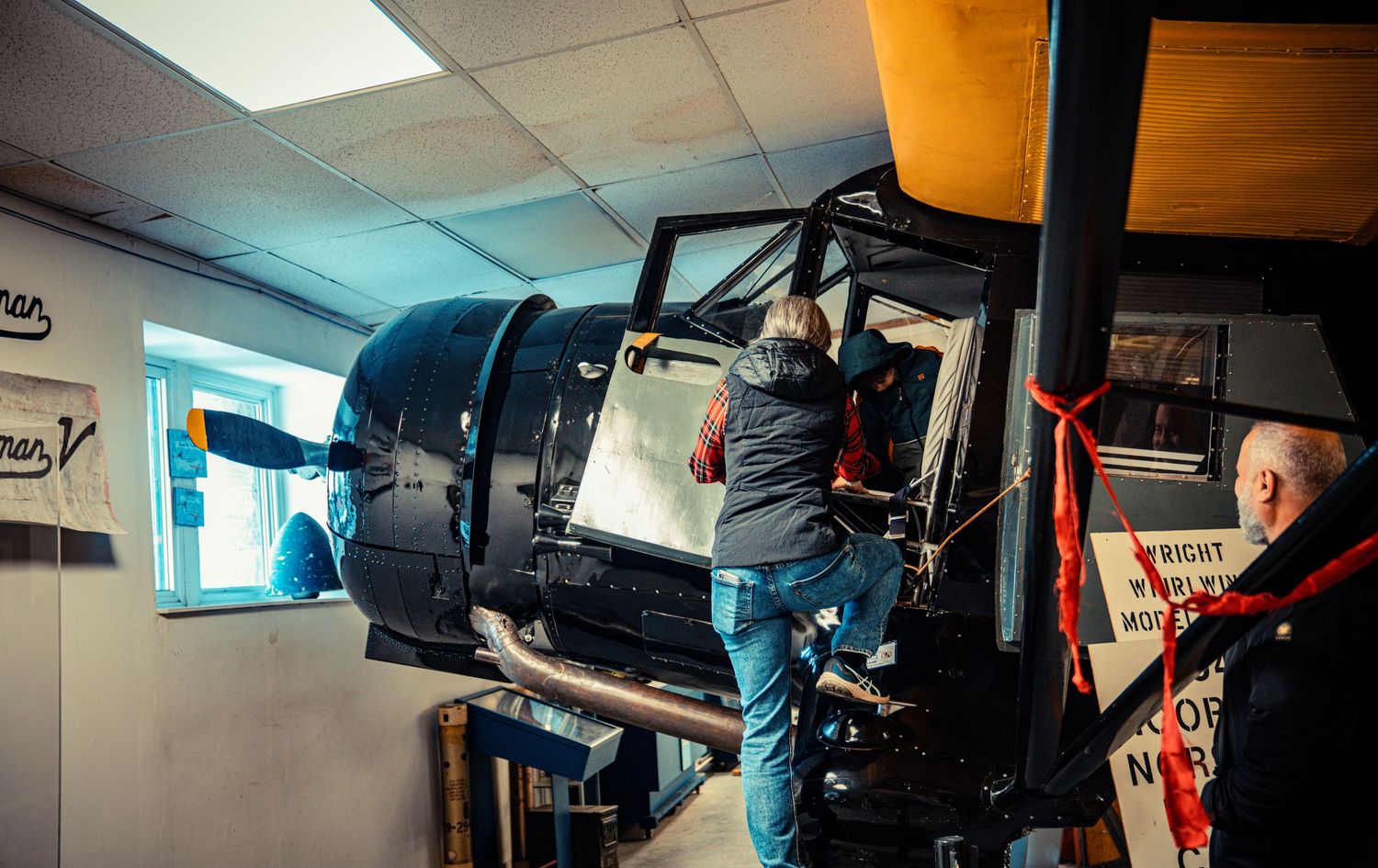 Auto repair shop interior showing mechanical equipment and vehicle lifts under fluorescent lighting.