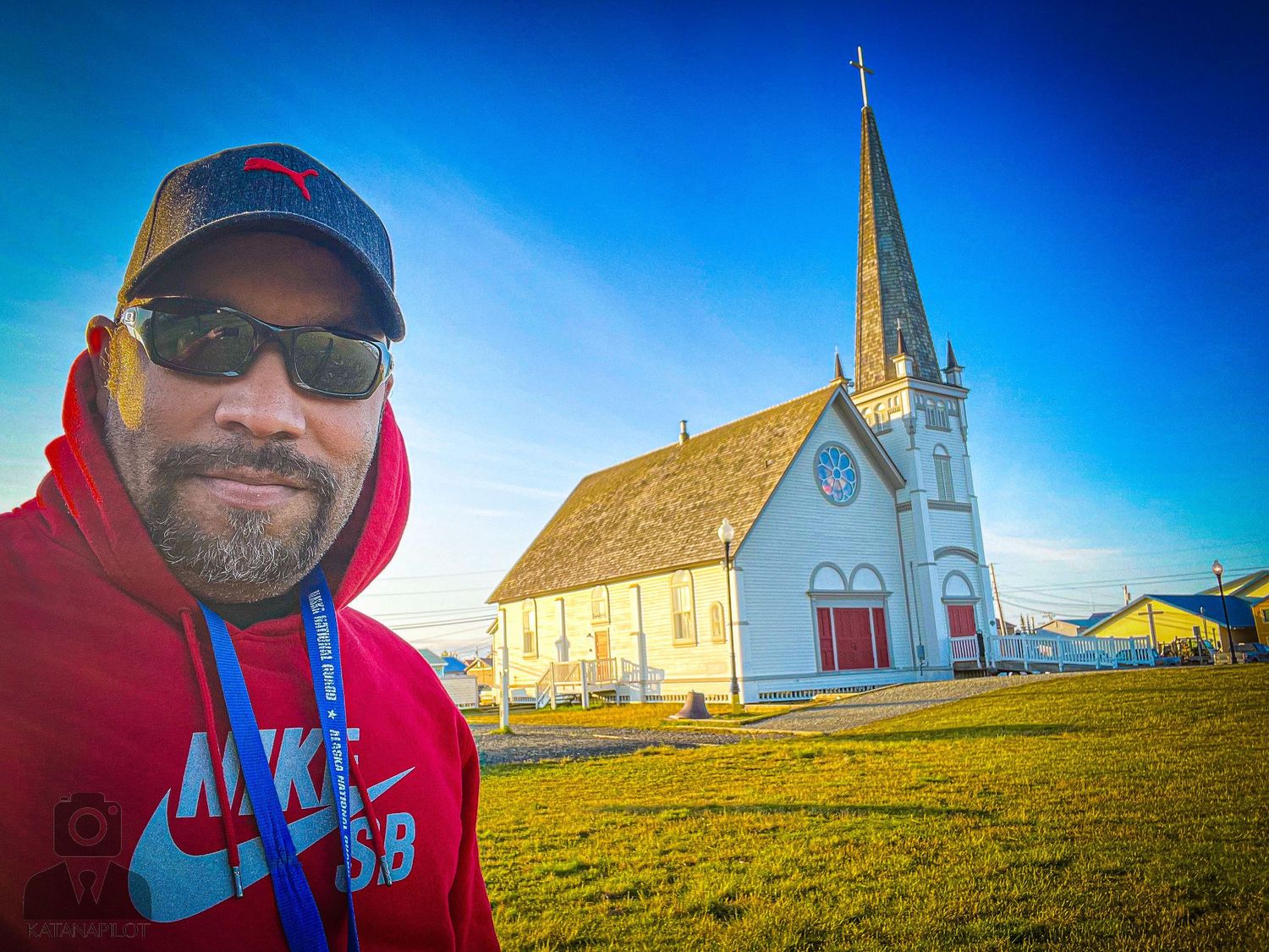 White church steeples and buildings against a bright blue sky in Nome, Alaska.