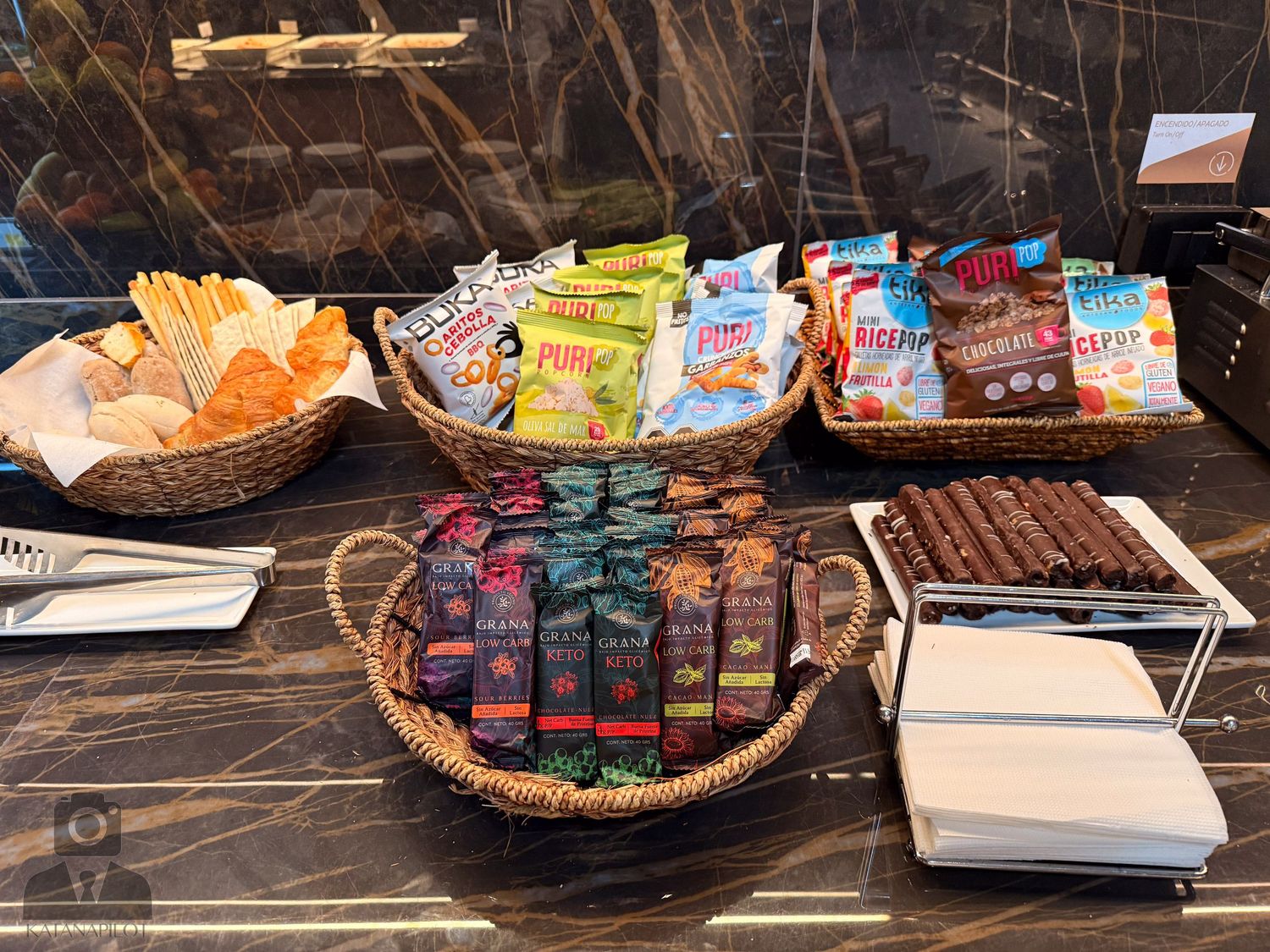 Retail display of packaged snacks and drinks in wooden baskets.