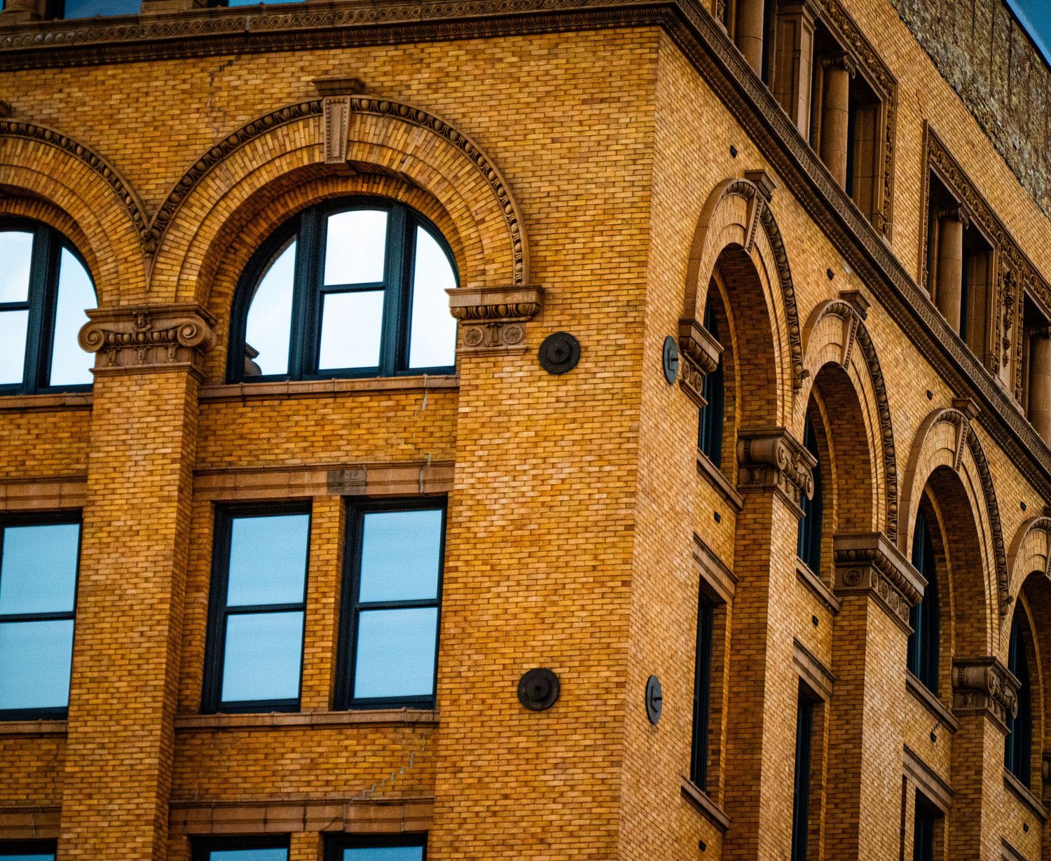 Arched brick windows and architectural details of a historic commercial building.