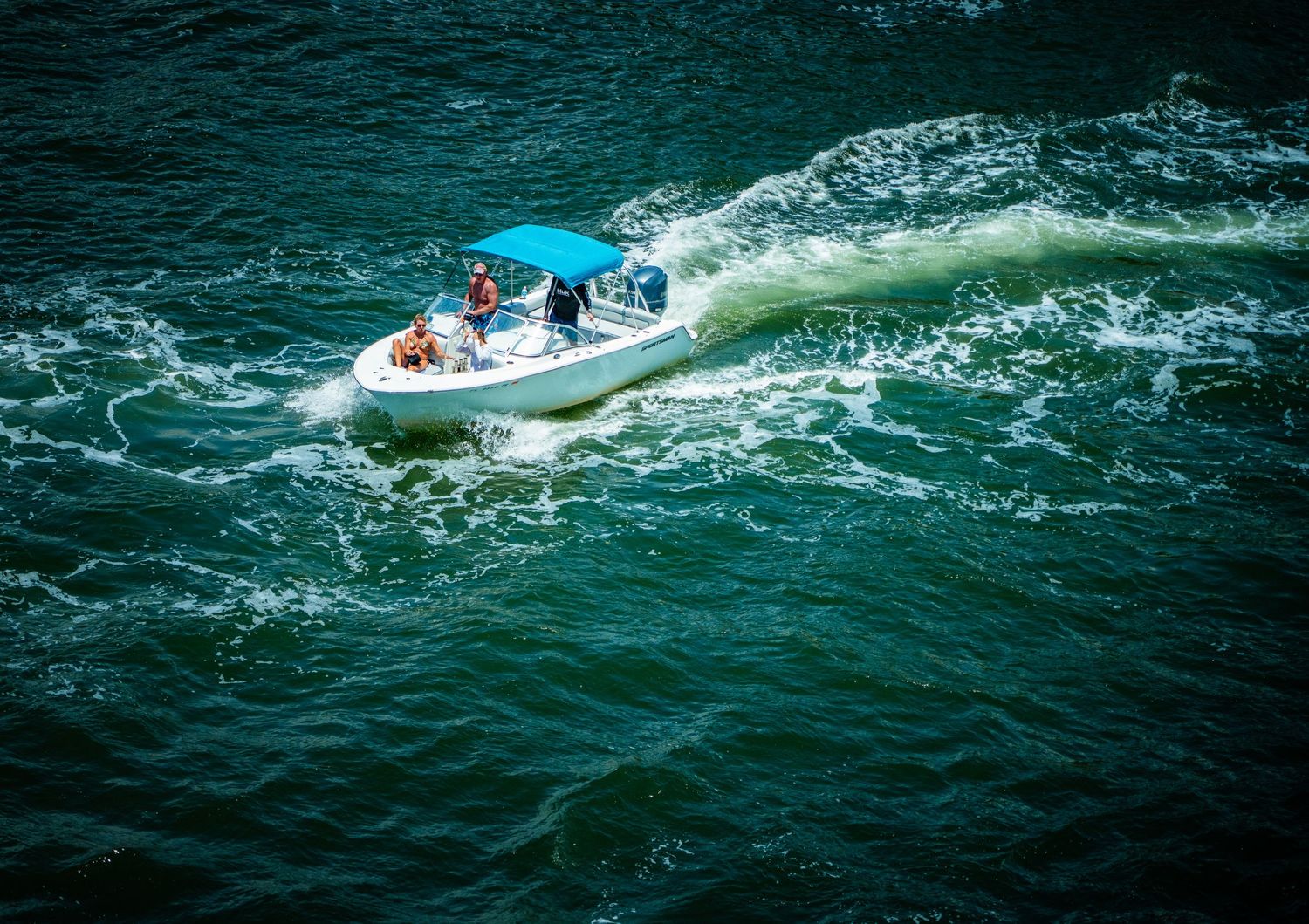 Sport fishing boats cutting through rough ocean waves at high speed.