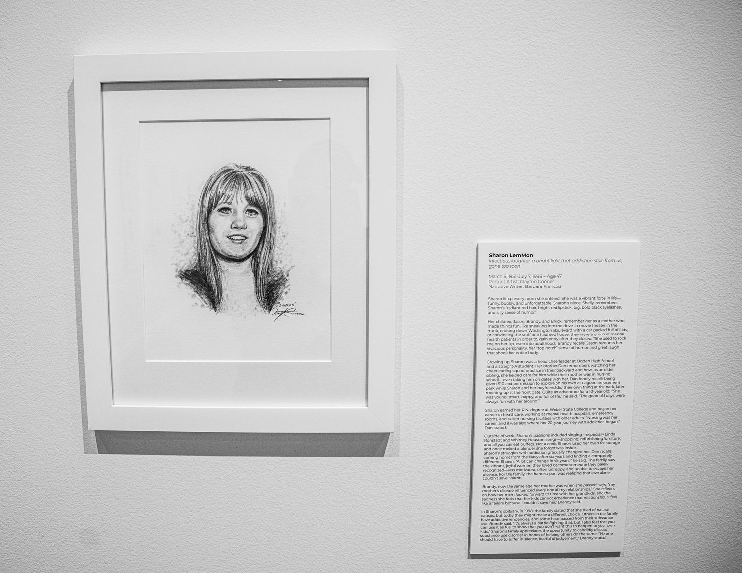Contemporary gallery space featuring mounted portrait sketches and story panels.