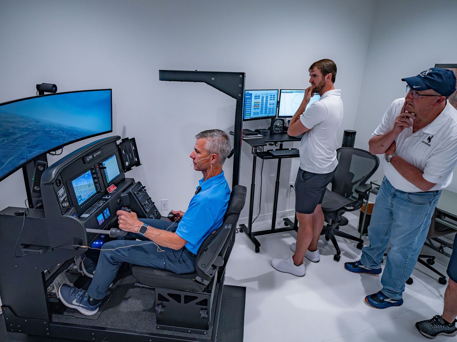 Flight simulator training session showing multiple monitors and controls in a professional aviation setup.