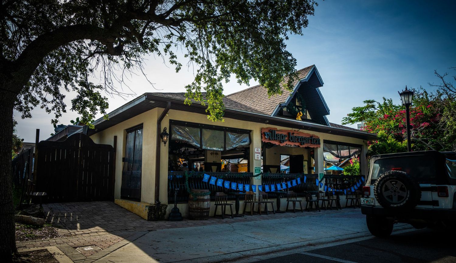 Small cafe building with blue bunting decorations and outdoor seating area.