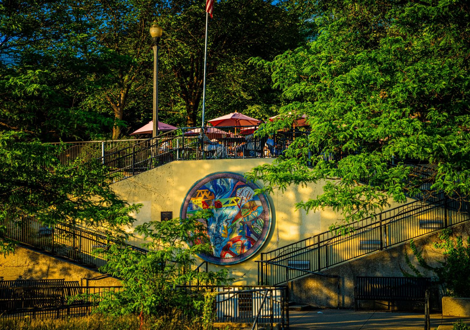Winding pathway through lush green park space with colorful art installations.