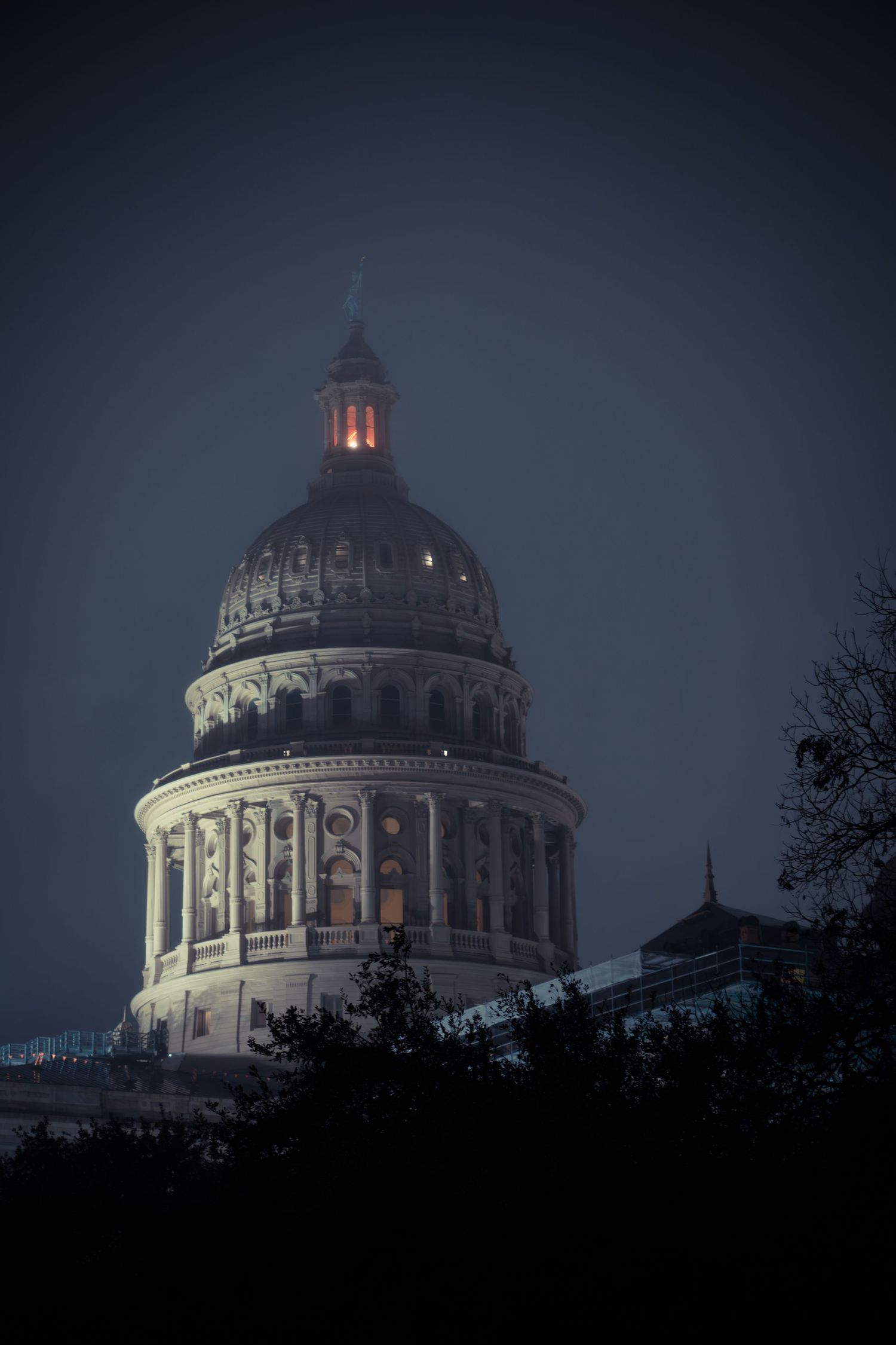 Historic domed capitol building photographed at dusk with dramatic lighting.