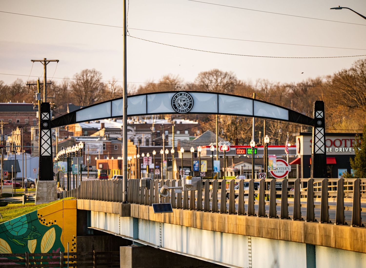 Vintage train station entrance with metal archway and signage at dusk.