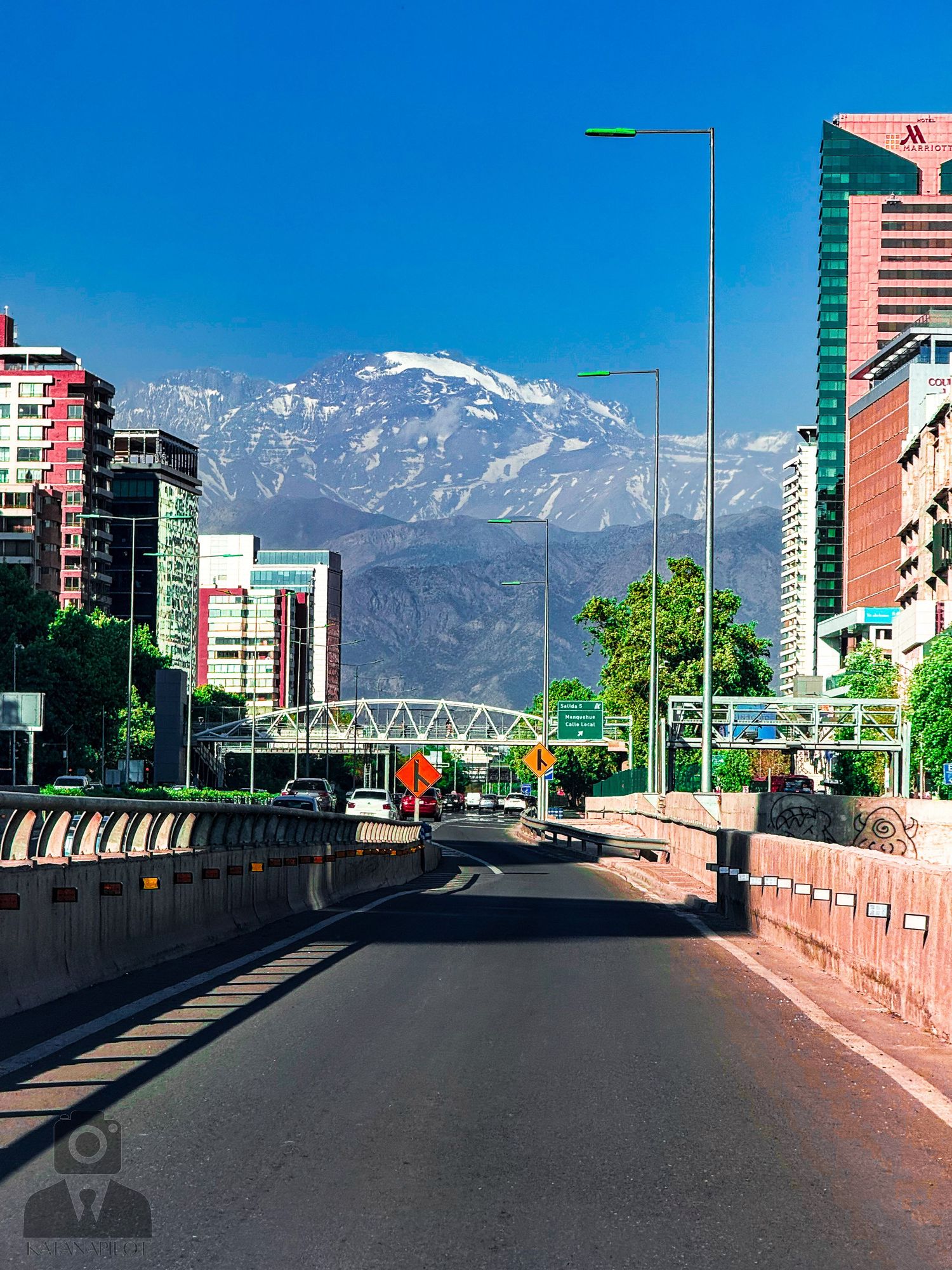 Urban road with mountain views and modern buildings in Santiago, Chile.
