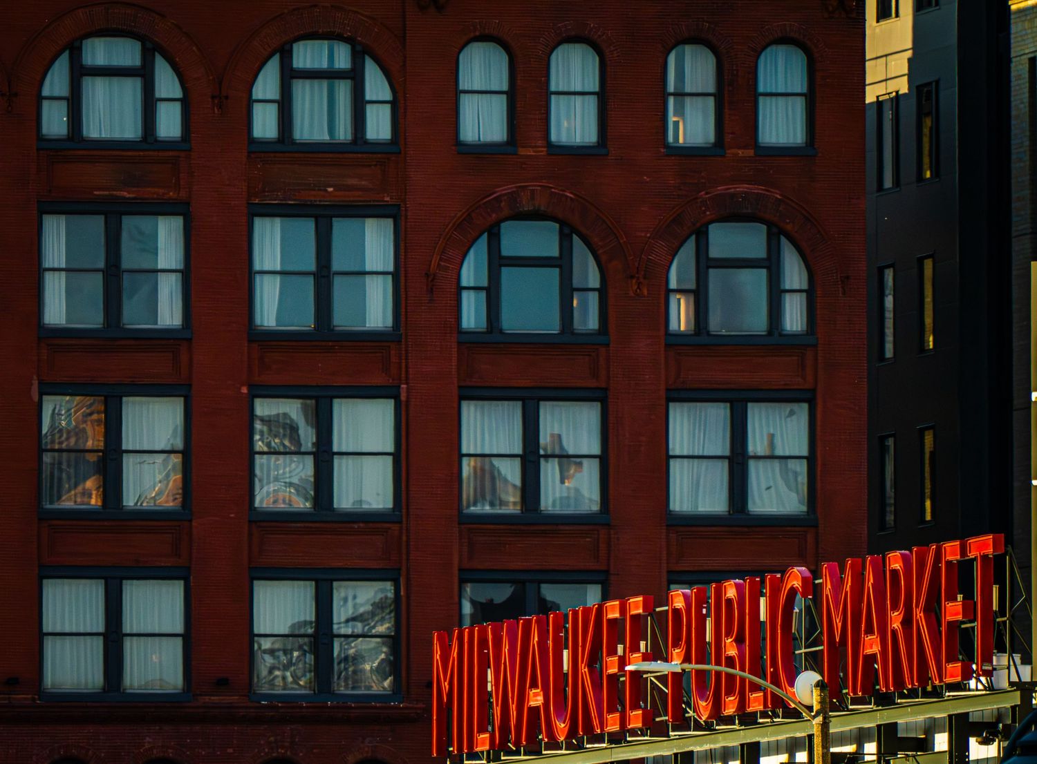 Red brick building facade with illuminated neon signage at night.