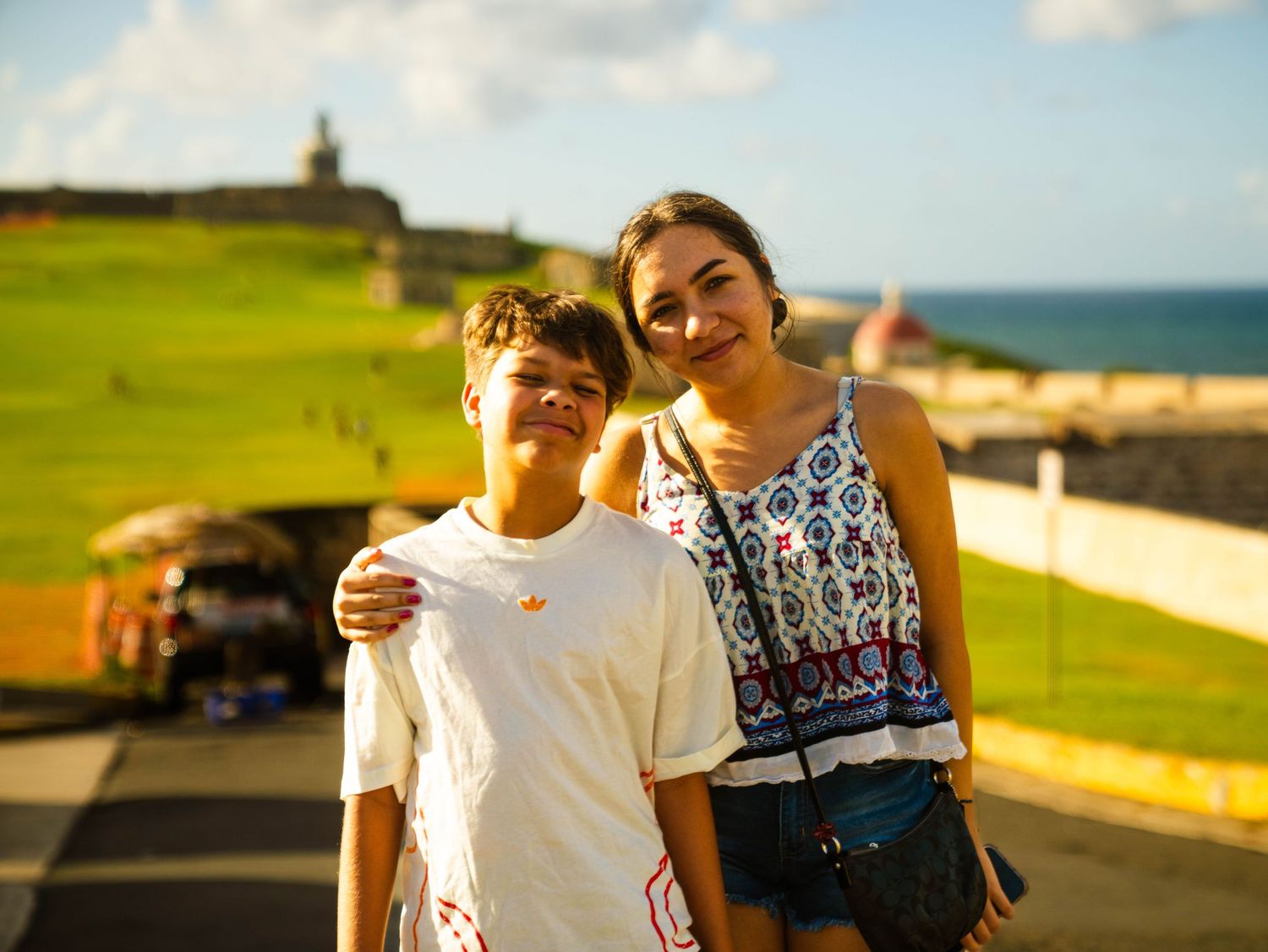 A group enjoys a sunny day along the coastal pathway with ocean views in the background.