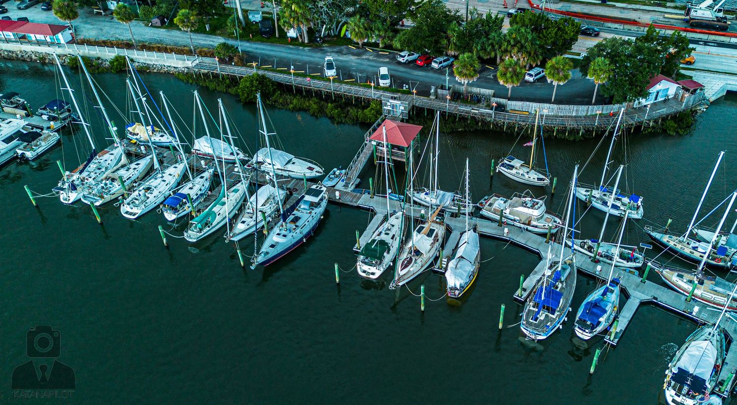 Birds-eye view of marina showing rows of docked boats and waterfront facilities.