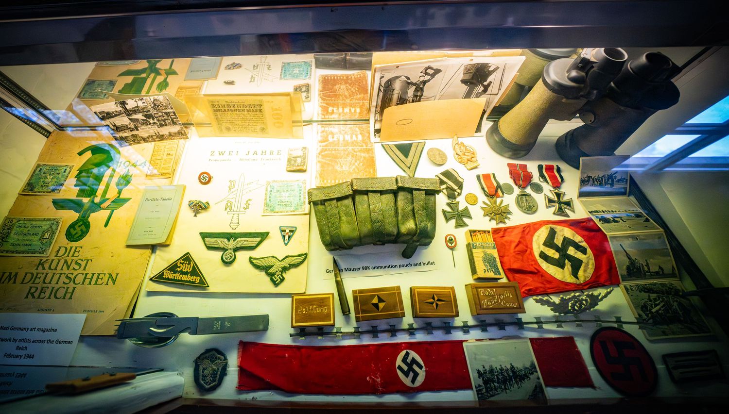 Historical exhibit displaying military and wartime memorabilia along wall.