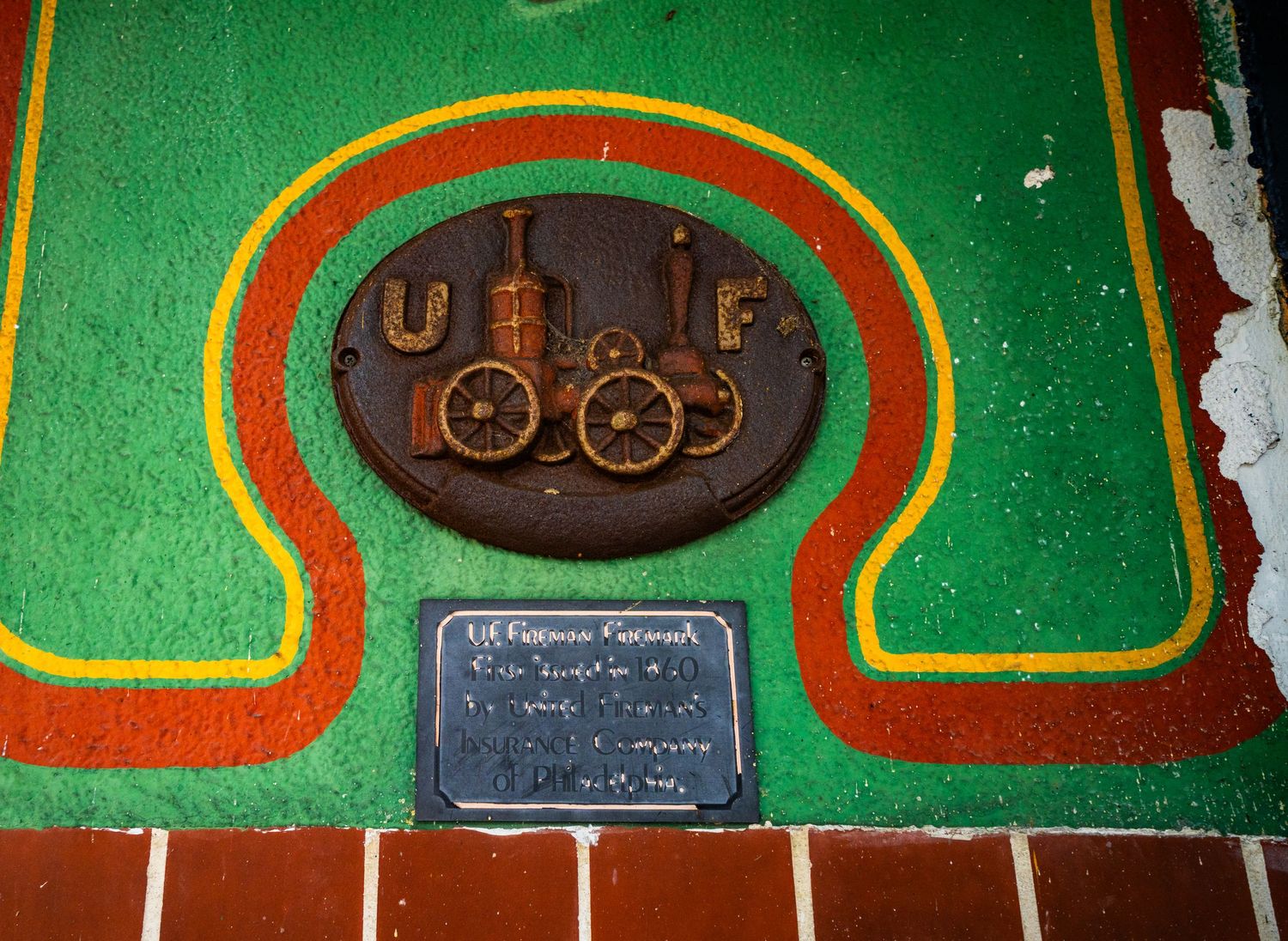 Vintage UF railroad logo embedded in green and orange decorative flooring.