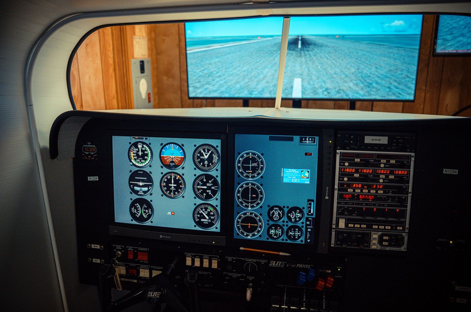 Aircraft cockpit instrument panel showing blue horizon displays and flight controls.