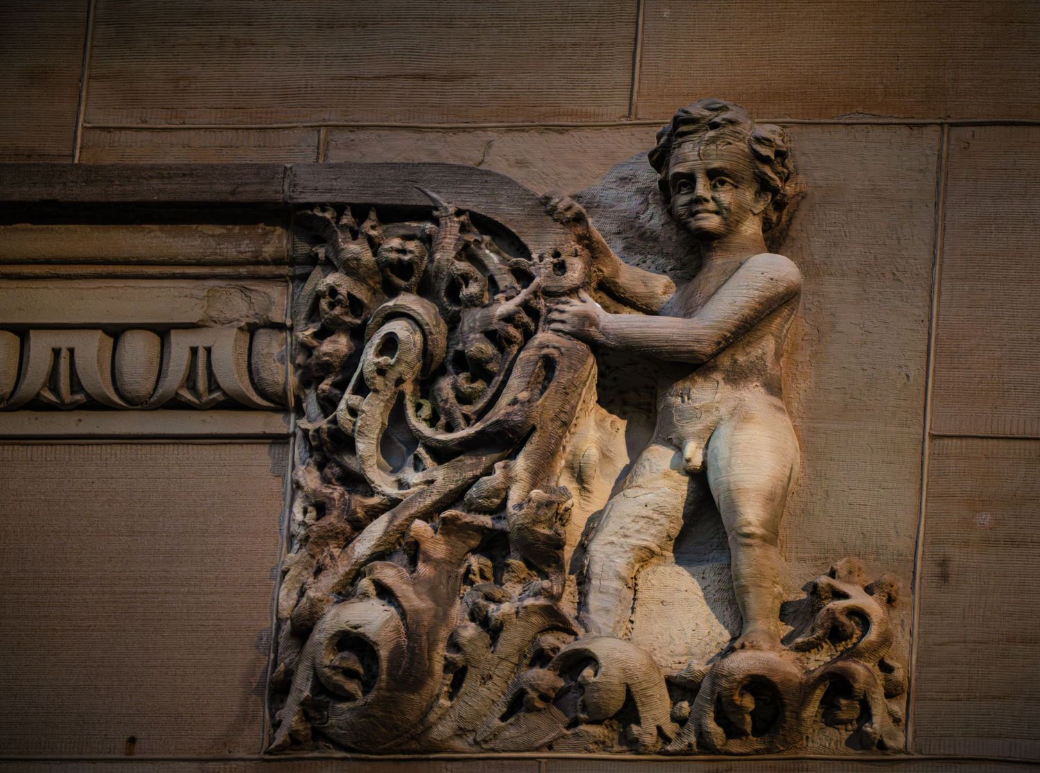 Detailed stone carving showing baroque architectural ornamentation on building facade.