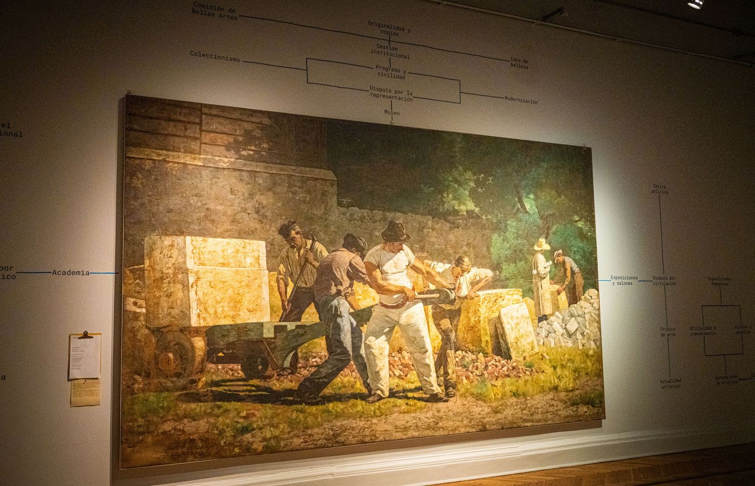 Large historical painting depicting rural laborers at work displayed in museum lighting.