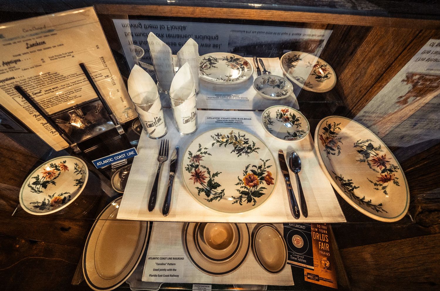 Elegant place setting with vintage plates and cutlery arranged on a wooden table.