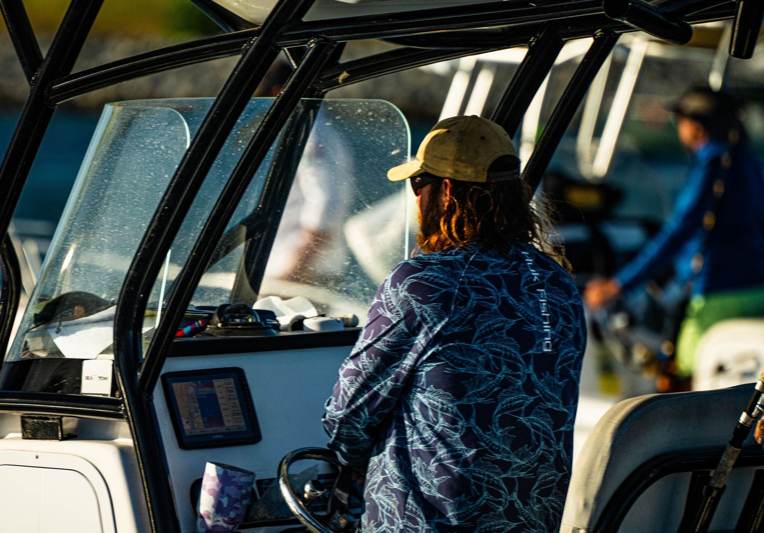 Bus driver operating a city transit bus while wearing a blue uniform during a daytime route.