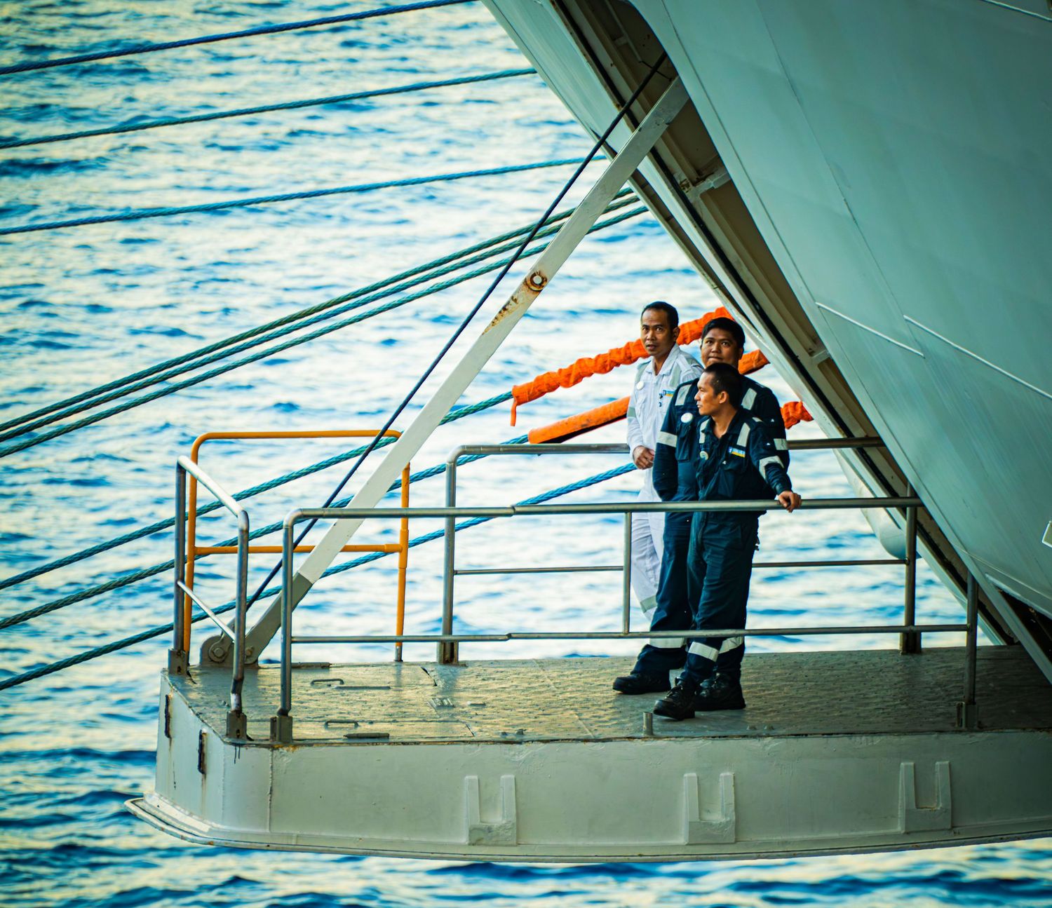 Multiple views of a yacht's deck with railings and ocean water in the background.