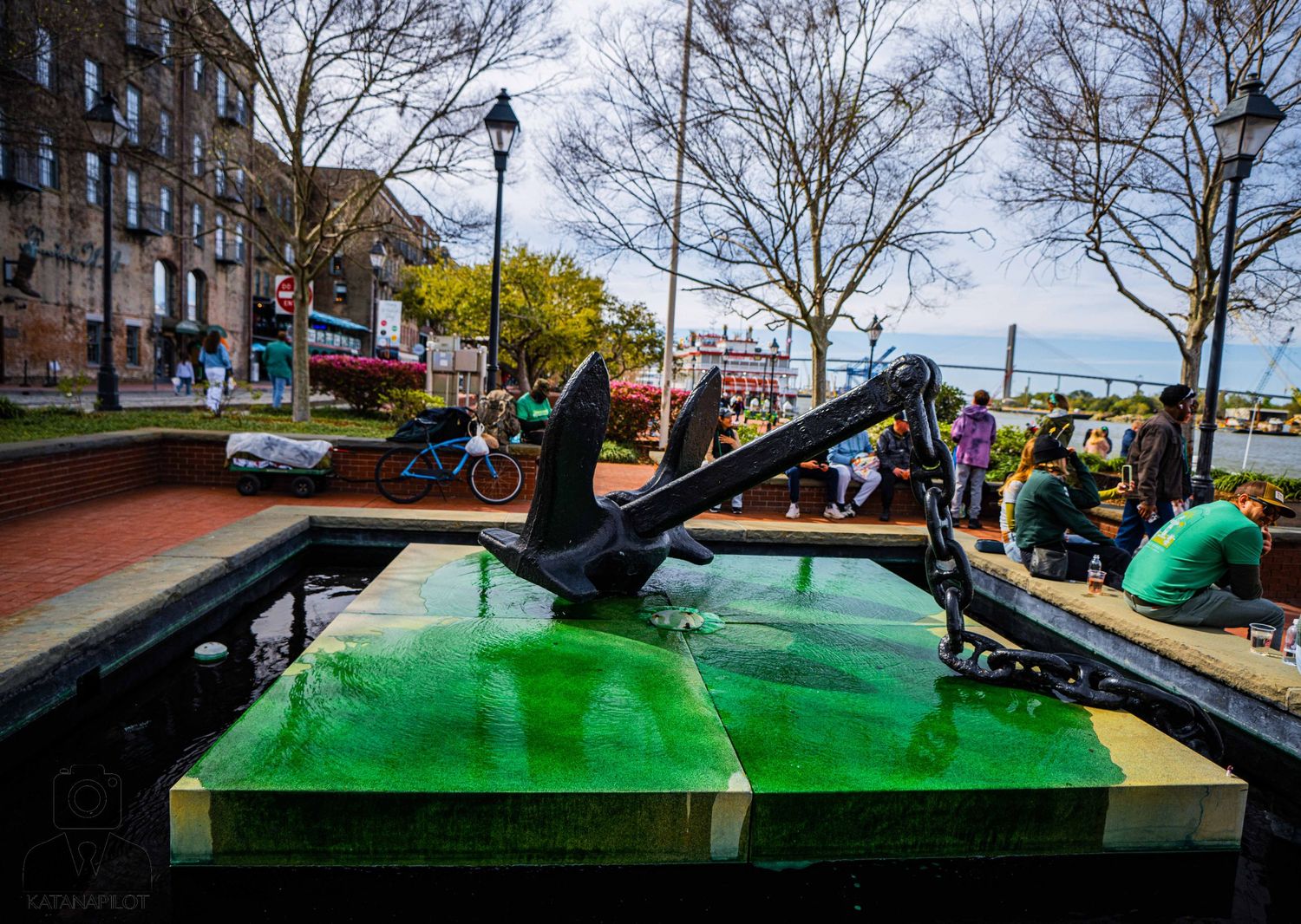 Row of outdoor ping pong tables with green surfaces set up in an urban park setting.