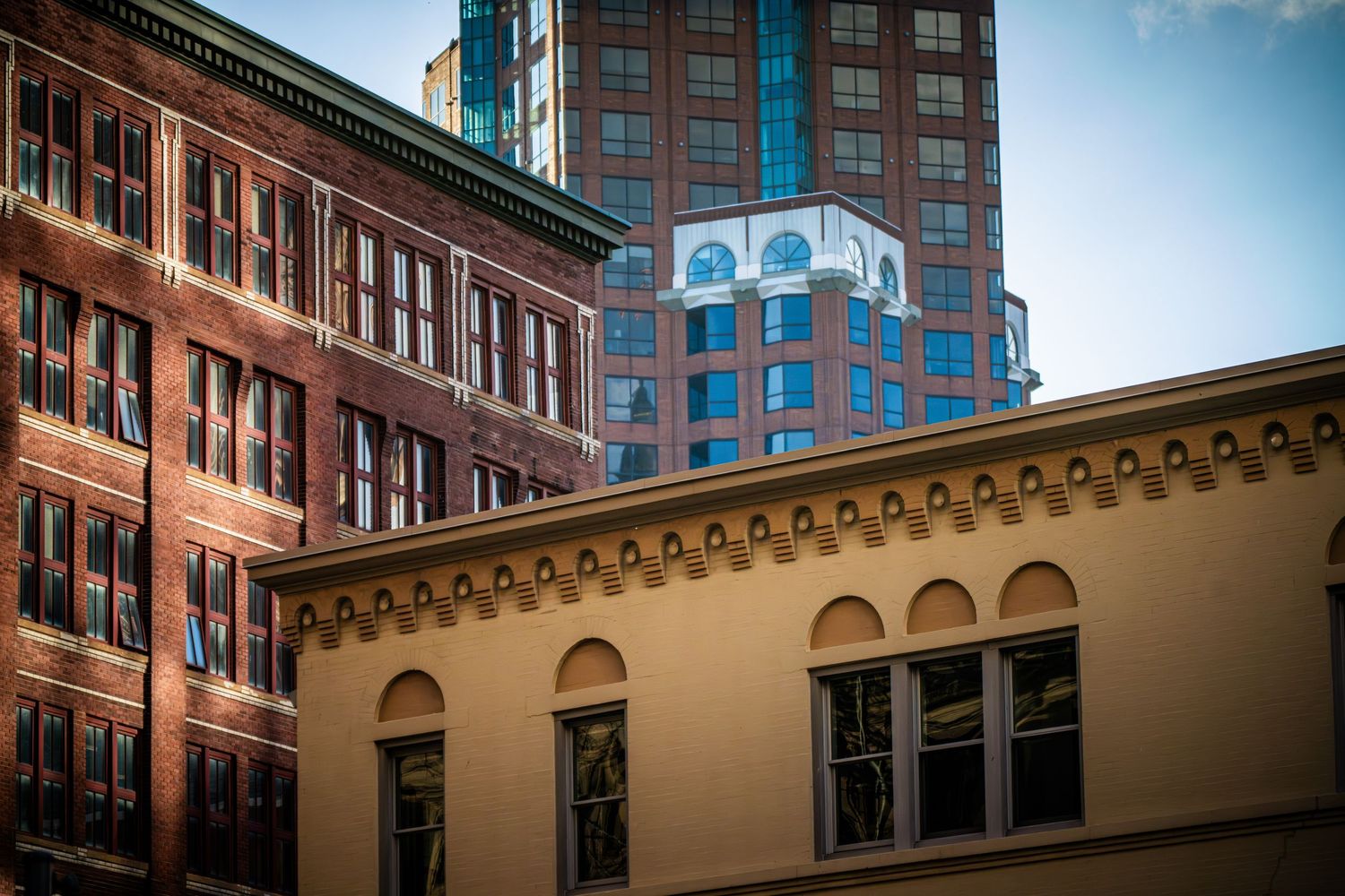 Historic brick building facade with ornate architectural details and modern glass windows.