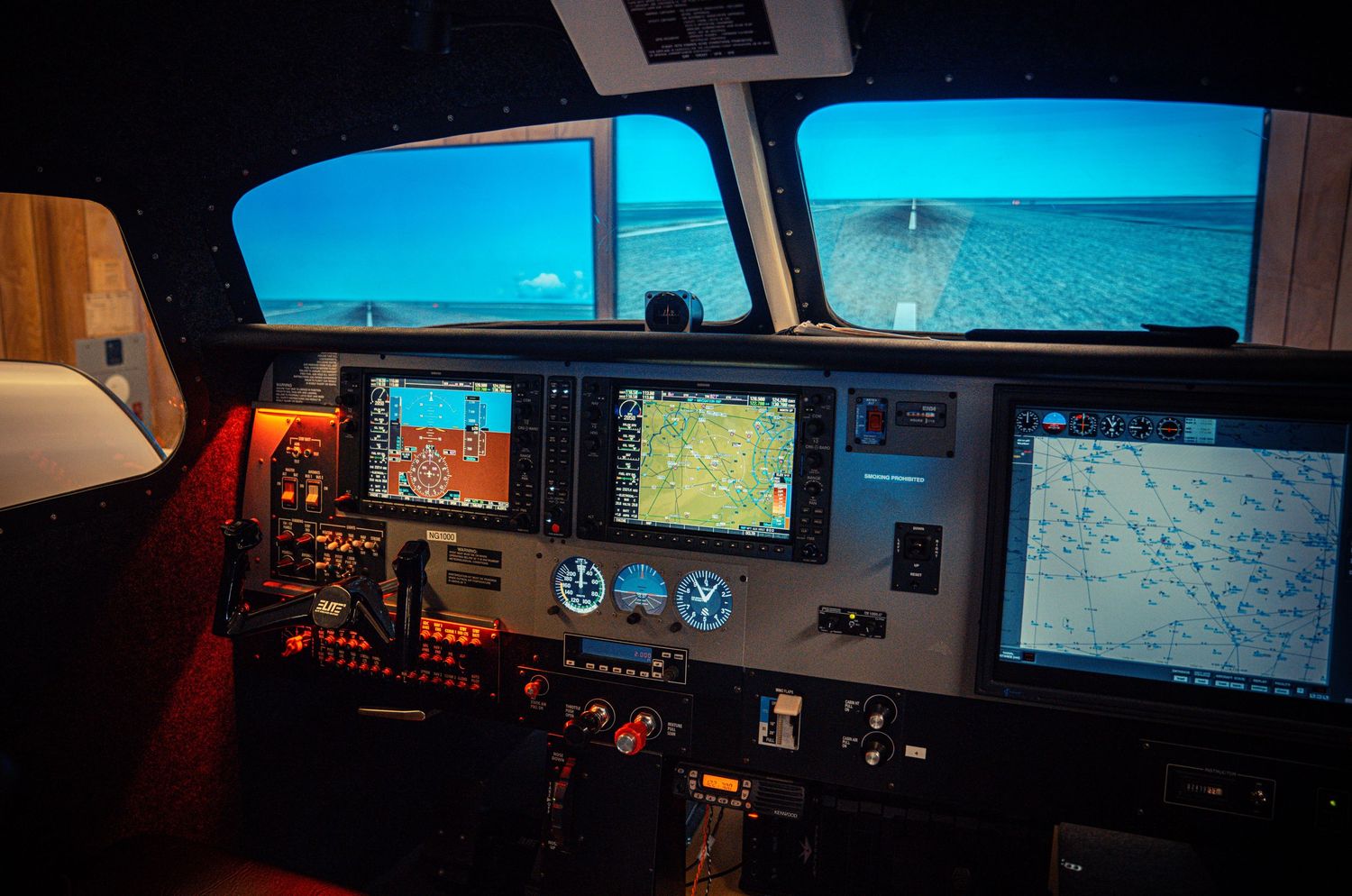 Modern airplane cockpit view with digital displays showing blue sky conditions.