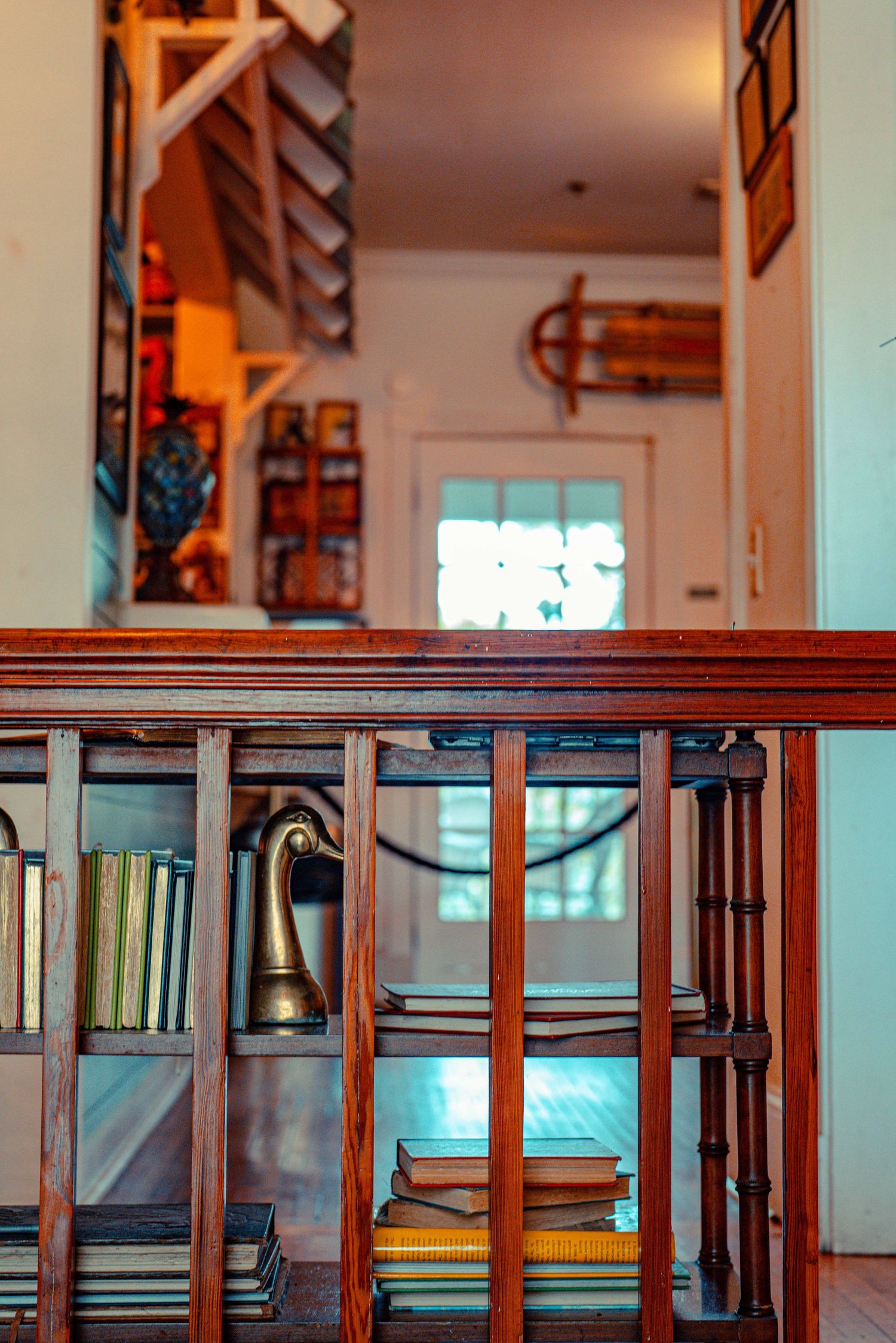 Wooden handrails and metal spindles line a staircase in a residential interior with warm lighting.