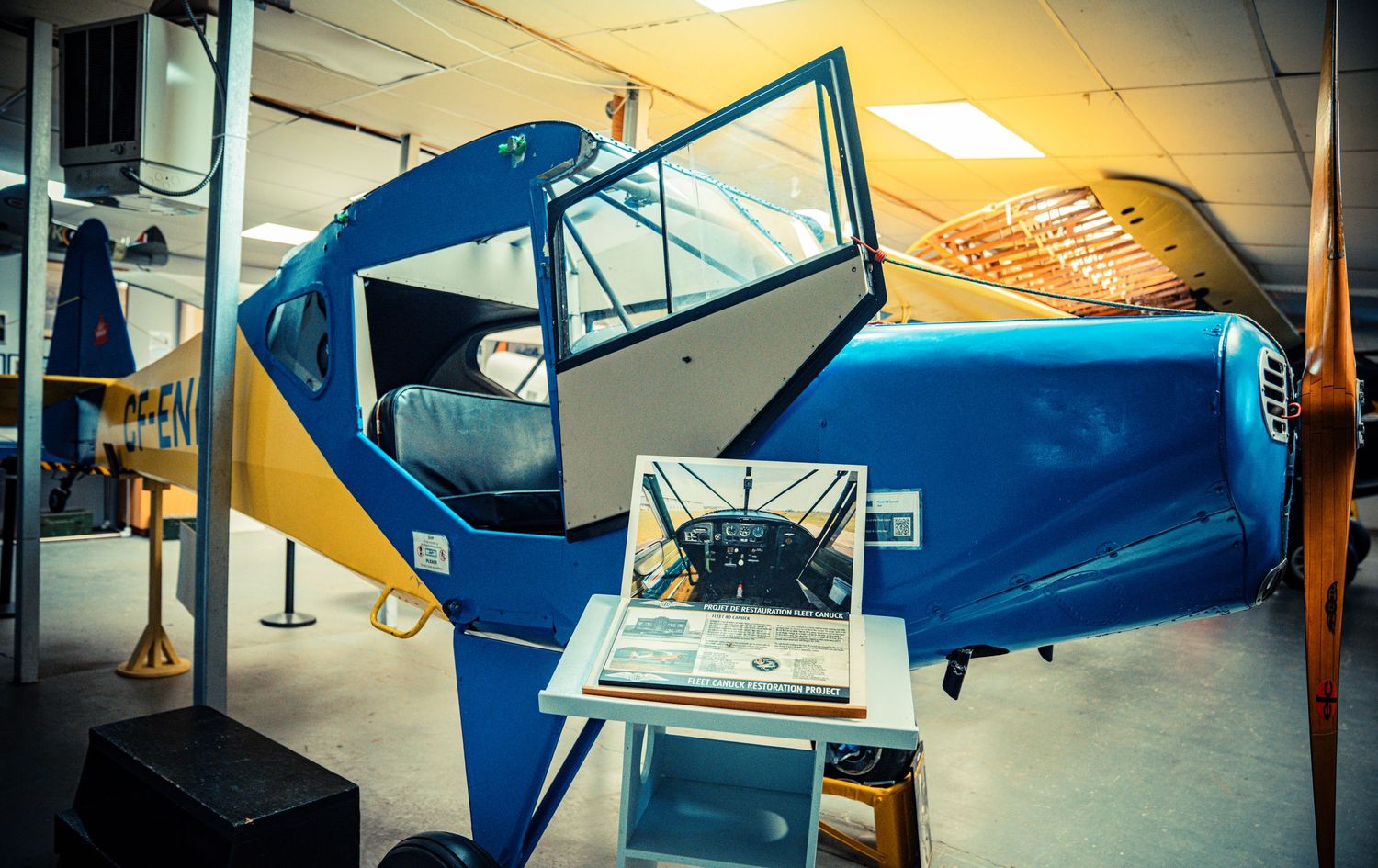 Blue vintage aircraft cockpit display with instrument panel and educational materials.