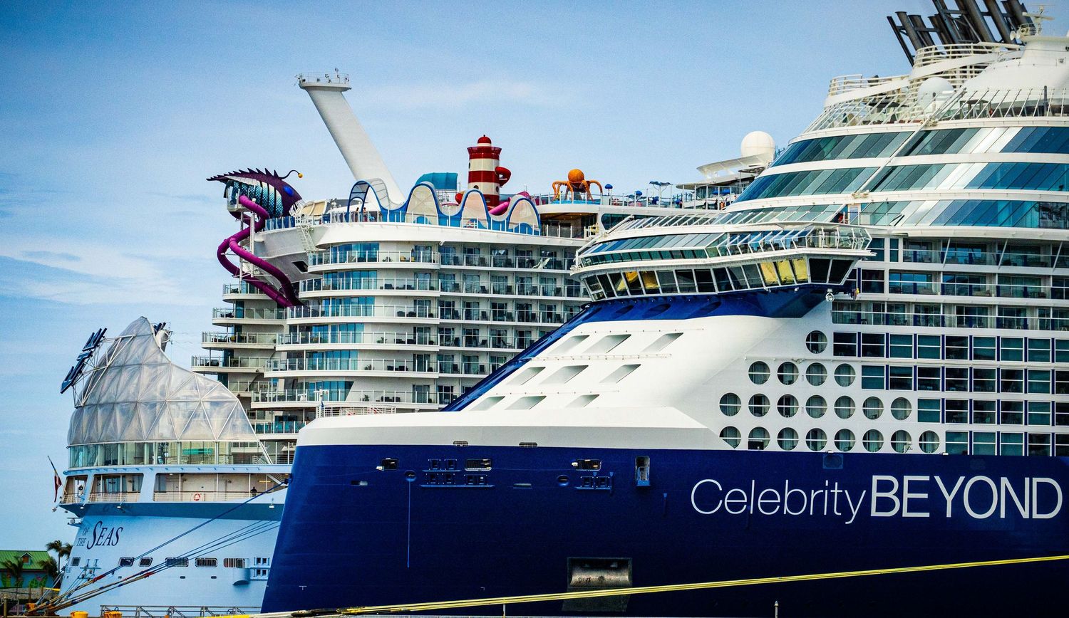 Celebrity Beyond cruise ship docked at port alongside another large cruise ship on a sunny day.