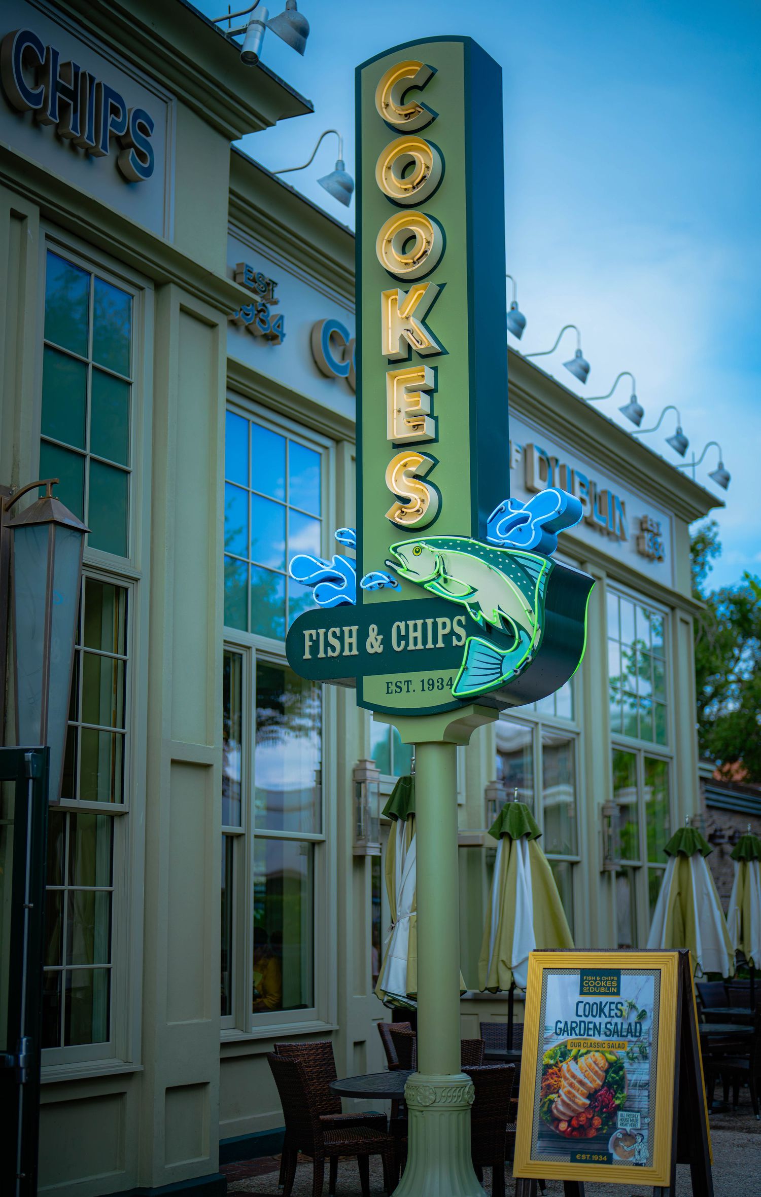 Cookes Fish & Chips restaurant sign established 1955, featuring neon fish logo outside a charming waterfront eatery.