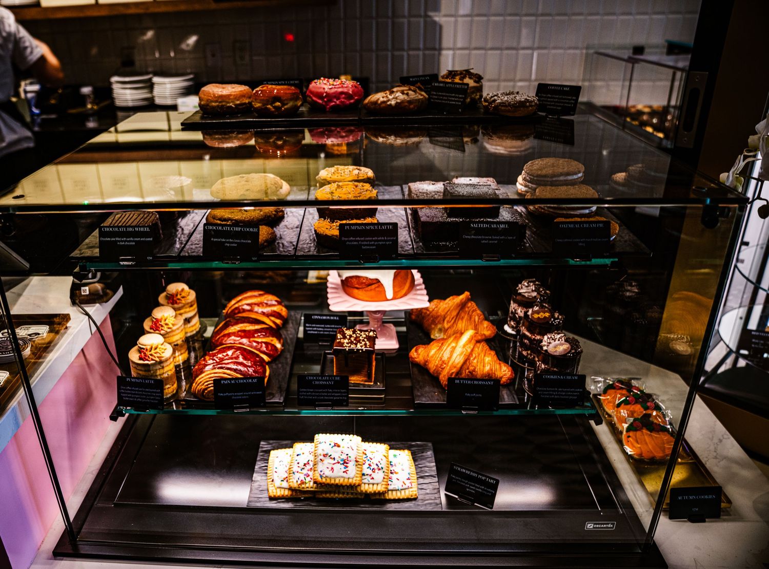 Glass display case filled with artisanal donuts and pastries in various flavors and toppings.